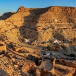 Dans la région montagneuse et désertique du Dahar, Chenini et Douiret sont deux villages citadelles construits sur des éperons rocheux. Chenini et les Sept Dormants Le ksar de Chenini est un ancien grenier fortifié au sommet d’une crête escarpée. Tout autour, les habitations sont en partie creusées dans le rocher. Non loin du village se trouve la Mosquée des Sept Dormants, entourée de sept tombes géantes. On dit que ce sont celles d’hommes persécutés à l’époque romaine, et qui se seraient réveillés là après trois siècles de profond sommeil. Une légende qui ressemble au récit des Gens de la Caverne dans la tradition musulmane, ou des Sept Dormants dans la tradition chrétienne. Douiret et l’ancienne oasis Sur la route de Douiret, on rencontre un cours d’eau bordé de palmiers : c’est une ancienne oasis qui s’étend sur six kilomètres. Comme Chenini, le village de Douiret est formé d’habitations creusées au flanc d’un piton rocheux, suivant les méandres des couches géologiques. Elles sont surmontées d’un ksar, ancien grenier citadelle. Le village possède aussi une mosquée souterraine. Aujourd’hui inhabité, Douiret était autrefois un relais caravanier prospère. Du sommet, la vue sur les paysages du Dahar est spectaculaire. A Chenini ou à Douiret, on peut faire l’expérience de la vie troglodyte en passant la nuit dans des habitations souterraines aménagées pour les voyageurs : - Résidence Kenza, Chenini - Résidence Douiret Les Troglodytiques - Gîte de Douiret chez Raouf