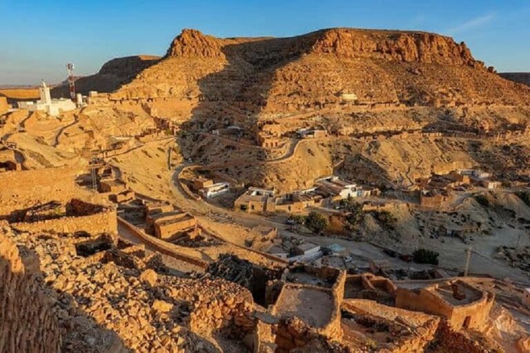 Dans la région montagneuse et désertique du Dahar, Chenini et Douiret sont deux villages citadelles construits sur des éperons rocheux. Chenini et les Sept Dormants Le ksar de Chenini est un ancien grenier fortifié au sommet d’une crête escarpée. Tout autour, les habitations sont en partie creusées dans le rocher. Non loin du village se trouve la Mosquée des Sept Dormants, entourée de sept tombes géantes. On dit que ce sont celles d’hommes persécutés à l’époque romaine, et qui se seraient réveillés là après trois siècles de profond sommeil. Une légende qui ressemble au récit des Gens de la Caverne dans la tradition musulmane, ou des Sept Dormants dans la tradition chrétienne. Douiret et l’ancienne oasis Sur la route de Douiret, on rencontre un cours d’eau bordé de palmiers : c’est une ancienne oasis qui s’étend sur six kilomètres. Comme Chenini, le village de Douiret est formé d’habitations creusées au flanc d’un piton rocheux, suivant les méandres des couches géologiques. Elles sont surmontées d’un ksar, ancien grenier citadelle. Le village possède aussi une mosquée souterraine. Aujourd’hui inhabité, Douiret était autrefois un relais caravanier prospère. Du sommet, la vue sur les paysages du Dahar est spectaculaire. A Chenini ou à Douiret, on peut faire l’expérience de la vie troglodyte en passant la nuit dans des habitations souterraines aménagées pour les voyageurs : - Résidence Kenza, Chenini - Résidence Douiret Les Troglodytiques - Gîte de Douiret chez Raouf