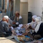 Excursion Matmata Douz au départ de Djerba Douz sud tunisien Ne manquez pas le marché de Douz, le jeudi matin, où la ville s’anime et vibre différemment. Il s’agit d’un des plus importants marchés de cette région. Vous croiserez ici des hommes tout droit sortis du désert, drapés dans leurs chèches colorés. Le marché occupe la place et la rue centrales, c'est un vaste lieu d’exposition pour les vendeurs qui ne cherchent pas à appâter le touriste, même si l’on y trouve quelques étalages d’artisanat. N'hésitez pas à boire un café au bord de la rue, vous en prendrez plein les yeux. Vous verrez des nomades venus vendre leurs fruits et légumes produits dans une des oasis de la région, ainsi que des marchands de vêtements artisanaux assez renommés. Mais c’est surtout pour son marché aux animaux, situé en contrebas, sur une place accolée à la palmeraie, que cette journée attire les fermiers de toute la région. Au pied des palmiers se bousculent moutons en grand nombre, poules, lapins, dans une atmosphère pleine de cris, de couleurs et d’odeurs inattendues. En fonction de la saison, vous verrez aussi des dromadaires. Une foule incroyable de personnes se presse auprès des bêtes. Les hommes d’un certain âge discutent ou jouent en tailleur à des jeux inconnus en attendant qu’un acheteur potentiel se présente, tandis que les plus jeunes surveillent les animaux impatients. Les enfants s’occupent de vendre des lapins et des poules qui leur permettent de s’aguerrir au métier. Un marché comme il est rare d'en voir, et une expérience 100% locale, car vous croiserez ici peu de touristes.