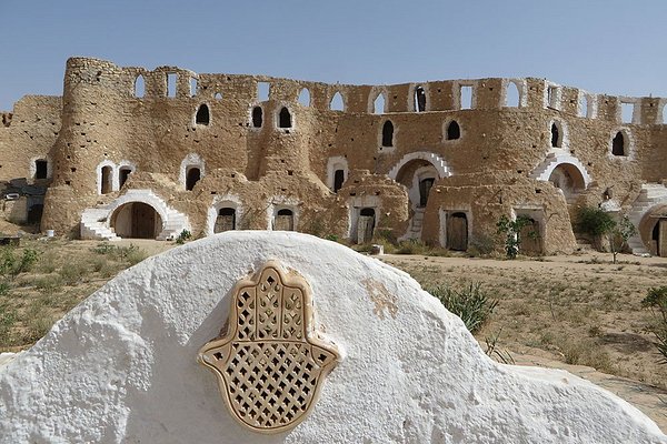 Matmata : Découvrez le Fascinant Pays des Habitants Souterrains Bienvenue à Matmata, une destination unique en Tunisie qui vous transportera dans un monde souterrain plein de mystères et de traditions séculaires. Si vous êtes un voyageur en quête d'authenticité et d'aventure, alors Matmata est l'endroit idéal pour vous plonger dans une expérience inoubliable. Un Paysage Étonnant : Les Maisons Troglodytes de Matmata Située dans le sud de la Tunisie, Matmata est célèbre pour ses maisons troglodytes étonnantes. Ces habitations creusées à même le sol sont l'œuvre des Berbères, les premiers habitants de la région, qui ont utilisé cette technique ingénieuse pour se protéger des températures extrêmes du désert. Imaginez-vous entrer dans ces maisons souterraines et découvrir leur fraîcheur apaisante. Les chambres rondes, creusées dans la roche, sont décorées de tapis colorés et de textiles traditionnels berbères, vous plongeant dans une ambiance chaleureuse et authentique. Un Patrimoine Culturel Riche : Les Traditions Berbères Matmata est également un véritable trésor culturel, préservant les traditions ancestrales des Berbères. Les habitants sont fiers de leur patrimoine et vous accueilleront avec une hospitalité chaleureuse. Assistez à des démonstrations de danses berbères envoûtantes, exécutées au rythme des tambourins et des chants traditionnels. Vous serez transporté dans un autre temps, où l'art et la culture étaient le cœur de la vie quotidienne. Des Excursions Passionnantes : Explorez les Environs de Matmata En plus de découvrir les habitations troglodytes, vous pouvez profiter d'excursions passionnantes autour de Matmata. Partez à dos de chameau pour explorer les dunes de sable du désert environnant, ou visitez les oasis verdoyantes qui ponctuent le paysage aride. À proximité de Matmata se trouve le pittoresque village de Toujane, perché sur une colline offrant une vue panoramique sur la région. Flânez dans les ruelles étroites et admirez l'architecture traditionnelle berbère qui témoigne de l'histoire riche de ce lieu. Savourez la Cuisine Locale : Un Délice pour les Papilles Après une journée d'aventures, laissez-vous tenter par la délicieuse cuisine locale de Matmata. Les plats traditionnels berbères mettent à l'honneur des ingrédients frais et locaux, offrant une explosion de saveurs dans chaque bouchée. Ne manquez pas de déguster le couscous, plat emblématique de la région, agrémenté de légumes colorés et de viandes tendres. Les tajines, mijotés lentement avec des épices exotiques, font également partie des délices culinaires à ne pas manquer. Conseils Pratiques pour Votre Séjour à Matmata Meilleure Période pour Visiter : Le printemps et l'automne offrent des températures agréables pour explorer Matmata sans souffrir de la chaleur estivale. Hébergement : Vous pouvez opter pour une expérience unique en séjournant dans une maison troglodyte transformée en auberge. Cela ajoutera une touche d'authenticité à votre séjour. Respectez les Traditions : En visitant Matmata, veillez à respecter les coutumes locales et à être sensible à la culture berbère. Explorez Matmata, un Trésor Caché En conclusion, Matmata est une destination extraordinaire qui vous fera vivre une expérience unique au cœur des traditions berbères. Découvrez les maisons troglodytes étonnantes, plongez dans le riche patrimoine culturel et explorez les environs fascinants de ce pays des habitants souterrains. Préparez-vous à être émerveillé par la beauté des paysages, l'hospitalité chaleureuse des habitants et la délicieuse cuisine locale. Matmata vous promet un voyage hors du temps, rempli d'aventures et de découvertes qui resteront gravées dans votre mémoire pour toujours.