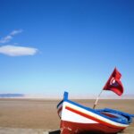 Excursion Sud Tunisie Chott El Jerid : À la Découverte de la Mer de Sel Si vous cherchez une aventure unique et captivante, ne cherchez pas plus loin que l'excursion dans le sud de la Tunisie, spécifiquement à Chott El Jerid. Loin des sentiers battus, cette escapade vous emmènera à travers un paysage époustouflant de contrastes, où la nature et la culture se fondent harmonieusement. Dans cet article, nous vous révélons tous les détails de cette excursion exceptionnelle, des dunes de sel scintillantes aux expériences locales inoubliables. Chott El Jerid : Un Monde de Sel et de Mystère Situé au cœur du sud tunisien, Chott El Jerid est l'un des plus grands lacs salés du pays. Imaginez un désert de sel s'étendant à perte de vue, avec des cristaux brillants à la surface, créant une illusion magique de miroirs d'eau. Lors de votre excursion, vous aurez la chance de traverser ce paysage irréel, où le ciel et la terre semblent se rencontrer à l'horizon. Randonnée dans les Dunes de Sel : Une Aventure Mémorable Les dunes de sel de Chott El Jerid offrent une opportunité unique de vivre une expérience de randonnée inédite. Enveloppé dans une palette de blancs et de bleus, vous vous aventurerez dans ce monde éthéré, explorant les dunes cristallines et laissant vos empreintes éphémères sur le sel. Lorsque le soleil se lève ou se couche, les teintes du paysage évoluent, créant des scènes dignes d'une œuvre d'art. Rencontres Authentiques : À la Découverte des Habitants de la Région Une excursion à Chott El Jerid ne se limite pas à la nature époustouflante. Vous aurez également l'occasion de rencontrer les habitants locaux, qui sont imprégnés de traditions riches et de chaleur humaine. Les villages berbères environnants vous accueilleront à bras ouverts, vous permettant de goûter à la cuisine locale et d'échanger des histoires avec les habitants. C'est une opportunité rare d'apercevoir la vie dans ces régions reculées, où l'hospitalité est une seconde nature. Conseils pour une Aventure Réussie à Chott El Jerid Pour tirer le meilleur parti de votre excursion à Chott El Jerid, voici quelques conseils à garder à l'esprit : 1. Préparez-vous aux Extrêmes Le climat dans le sud tunisien peut varier considérablement, des températures brûlantes pendant la journée aux nuits fraîches. Assurez-vous d'emporter des vêtements légers pour la journée et des couches chaudes pour la nuit. N'oubliez pas votre protection solaire et votre chapeau. 2. Soyez Respectueux de la Culture Locale Lorsque vous visitez les villages berbères, montrez du respect envers les coutumes locales. Demandez la permission avant de prendre des photos des habitants et de leurs propriétés, et soyez ouvert à l'apprentissage de leurs traditions. 3. Optez pour un Guide Local Engager un guide local peut enrichir considérablement votre expérience. Les guides connaissent bien la région, son histoire et sa culture. Ils peuvent également vous emmener dans des endroits moins connus et vous fournir des informations précieuses. Une Aventure Hors du Commun Vous Attend En conclusion, une excursion à Chott El Jerid dans le sud tunisien est bien plus qu'un simple voyage. C'est une immersion dans un monde de sel et de mystère, une opportunité de marcher sur des dunes scintillantes et de rencontrer des gens accueillants. Préparez-vous à être émerveillé par la beauté brute de Chott El Jerid et à créer des souvenirs qui dureront toute une vie. Alors, embarquez pour cette aventure exceptionnelle et découvrez un aspect inexploré de la Tunisie.