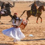 Découvrez l'Exaltation du Festival de Douz dans le Sud de la Tunisie Le festival de Douz, une célébration vibrante au cœur du sud de la Tunisie, est bien plus qu'un simple événement. C'est une expérience immersive qui vous transporte au cœur de la culture riche et de la joie contagieuse de la région. Dans cet article, nous vous plongeons dans l'univers enivrant du festival de Douz, en vous dévoilant tout ce que vous devez savoir pour vivre une aventure inoubliable. L'Effervescence Culturelle au Festival de Douz Le festival de Douz, connu également sous le nom de Festival des Dattes, est une explosion de couleurs, de danses, de musiques et de traditions. Chaque année, des milliers de visiteurs affluent vers cette petite ville du sud de la Tunisie pour participer à cette célébration unique. Des costumes traditionnels chatoyants aux rythmes envoûtants des tambours, l'effervescence culturelle vous enveloppe dès votre arrivée. Un Voyage au Cœur du Désert Le festival de Douz se déroule au beau milieu du désert, ajoutant une touche encore plus spéciale à l'événement. Les dunes de sable doré offrent un cadre pittoresque et enchanteur pour les festivités. Vous pourrez vous perdre dans les ruelles du marché coloré, où des échoppes offrent des trésors artisanaux uniques, des tapis tissés à la main aux bijoux traditionnels. Une immersion totale dans la culture saharienne vous attend. Spectacles Époustouflants et Compétitions Captivantes Le point d'orgue du festival est le spectacle de fantasia, une démonstration équestre époustouflante qui met en avant l'adresse et la maîtrise des cavaliers. Les chevaux lancés au galop, les costumes traditionnels et les tirs de fusils en l'air créent une ambiance électrisante. De plus, ne manquez pas les compétitions de course de chameaux, où ces majestueux animaux rivalisent dans des courses passionnantes. Gastronomie et Saveurs Uniques Le festival de Douz est aussi un voyage gustatif à travers la cuisine locale. Les délices culinaires sahariens vous séduiront avec leurs saveurs authentiques. Goûtez aux dattes fraîches et aux plats traditionnels, tels que le couscous parfumé et les tajines délicieusement épicés. Les saveurs uniques de la région vous offriront une expérience culinaire mémorable. Préparez Votre Aventure au Festival de Douz Pour profiter pleinement du festival de Douz, une planification minutieuse est essentielle. Réservez vos hébergements à l'avance, car les places peuvent être limitées pendant l'événement. N'oubliez pas de vous habiller confortablement, car les journées peuvent être chaudes, mais les nuits sont fraîches dans le désert. Conclusion En somme, le festival de Douz dans le sud de la Tunisie est bien plus qu'une simple célébration. C'est une occasion de plonger dans la culture fascinante de la région, de vibrer au rythme des danses et des musiques, et de créer des souvenirs inoubliables. Si vous cherchez à vivre une expérience culturelle unique, le festival de Douz vous promet une aventure exceptionnelle que vous n'oublierez jamais.