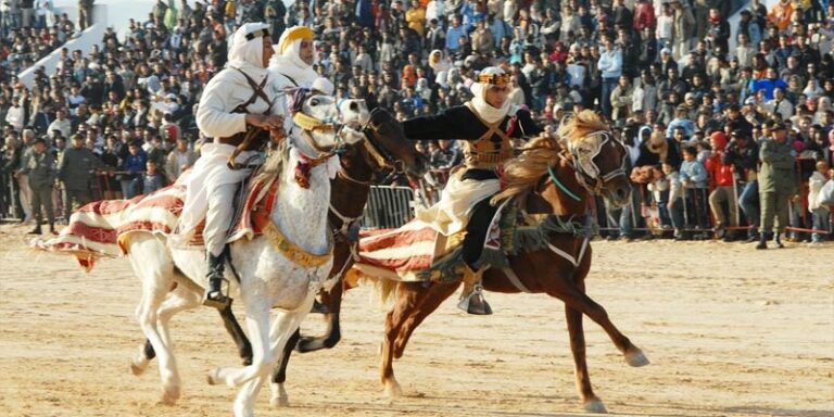 Le Festival de Douz est une célébration emblématique qui se déroule au cœur du désert tunisien. Organisé par SudTunisie.com, cet événement incarne l'essence de la culture saharienne et attire des visiteurs du monde entier. Dans cet article, nous plongeons au cœur de ce festival captivant et vous dévoilons ce qui en fait une expérience inoubliable. L'Héritage Culturel du Sud Tunisien Le Sud de la Tunisie est imprégné d'une histoire et d'une culture riches, façonnées par les tribus nomades berbères et arabes qui ont appelé cette région leur chez-soi pendant des siècles. Le Festival de Douz rend hommage à cette histoire en mettant en avant la musique, la danse, l'artisanat et la cuisine traditionnels. Musique et Danse Envoûtantes L'une des caractéristiques les plus marquantes du Festival de Douz est la musique saharienne envoûtante. Les groupes de musiciens locaux jouent des mélodies hypnotiques avec des instruments traditionnels tels que le oud et le bendir. Les danseurs exécutent des mouvements gracieux, créant une atmosphère enivrante qui vous transporte dans le désert même. Artisanat et Souks Les souks du Festival de Douz regorgent de trésors artisanaux uniques. Vous pouvez acheter des tapis berbères finement tissés, des bijoux traditionnels, des poteries et bien plus encore. C'est l'endroit idéal pour ramener chez vous des souvenirs authentiques de votre séjour dans le Sud de la Tunisie. Gastronomie Saharienne La cuisine saharienne est une expérience en soi. Vous pourrez déguster des plats délicieusement épicés, préparés avec des ingrédients locaux. Ne manquez pas de goûter au couscous saharien, au méchoui, et aux dattes fraîches qui sont abondantes dans la région. Expérience Bédouine Pour vivre pleinement l'expérience du Festival de Douz, de nombreux visiteurs optent pour passer une nuit dans le désert. Vous pourrez séjourner dans des tentes bédouines traditionnelles, admirer le ciel étoilé, et écouter les légendes du désert racontées par les habitants. C'est une expérience qui vous connectera profondément à la culture saharienne. Participer au Festival Le Festival de Douz se tient généralement en décembre, lorsque les températures dans le désert sont plus clémentes. Pour participer à cette célébration unique, vous pouvez réserver vos billets et votre hébergement à l'avance sur le site Web de SudTunisie.com. Assurez-vous de planifier votre voyage à l'avance, car cet événement est très populaire et attire de nombreux visiteurs. Le Festival de Douz est bien plus qu'une simple célébration. C'est une plongée au cœur de la culture saharienne, une expérience immersive qui vous transporte dans un autre monde. Si vous cherchez une aventure culturelle authentique dans le Sud de la Tunisie, ne manquez pas cette occasion unique de découvrir le Festival de Douz avec SudTunisie.com. Préparez vous à être envoûté par la musique, à être émerveillé par l'artisanat, à déguster des saveurs sahariennes et à vivre une expérience bédouine inoubliable. Le Festival de Douz est un trésor du Sud de la Tunisie qui mérite d'être découvert et célébré.