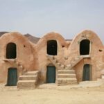 Le sud de la Tunisie est une région riche en histoire, en culture et en paysages à couper le souffle. Cette région désertique offre une expérience unique pour les voyageurs en quête d'aventure et de découvertes authentiques. De ses vastes dunes de sable aux oasis luxuriantes, en passant par les ksour ancestraux, le sud tunisien est une véritable invitation au voyage. Circuit Sud Tunisien 2024 : Préparez-vous à l'Aventure Le circuit du sud tunisien en 2024 promet d'être une aventure inoubliable. En trois jours, vous aurez l'occasion de découvrir les sites les plus emblématiques de la région. Voici un aperçu de ce que vous pouvez attendre : Jour 1 : Tozeur et les Oasis de Montagne Votre aventure commence à Tozeur, une ville oasis située à l'entrée du désert du Sahara. Connue pour ses palmeraies et ses maisons en briques d'argile, Tozeur est un véritable joyau du sud tunisien. Vous pourrez visiter la médina, flâner dans ses ruelles étroites et découvrir les artisans locaux. Ensuite, direction les oasis de montagne, telles que Chebika, Tamerza et Midès. Ces oasis offrent des paysages spectaculaires avec des cascades, des canyons et des palmiers à perte de vue. Jour 2 : Chott el-Jérid et Douz Le deuxième jour de votre circuit vous mènera à travers le Chott el-Jérid, un vaste lac salé qui offre des vues époustouflantes, surtout au lever et au coucher du soleil. Ensuite, cap sur Douz, souvent appelée la "porte du désert". À Douz, vous pourrez monter à dos de chameau et vous aventurer dans les dunes de sable doré du Sahara. Ne manquez pas le marché hebdomadaire de Douz, où vous pourrez découvrir l'artisanat local et déguster des spécialités culinaires de la région. Jour 3 : Matmata et les Ksour Pour le dernier jour de votre circuit, direction Matmata, célèbre pour ses habitations troglodytes. Ces maisons creusées dans la roche offrent une fraîcheur bienvenue dans cette région aride. Vous pourrez visiter une maison troglodyte et découvrir le mode de vie des habitants. Ensuite, cap sur les ksour, ces greniers fortifiés typiques du sud tunisien. Ksar Ouled Soltane et Ksar Ghilane sont deux des plus impressionnants. Vous pourrez y admirer l'architecture unique et en apprendre davantage sur leur histoire. Sud Tunisien Description : Un Paysage Contrasté Le sud tunisien est une région de contrastes où se côtoient le désert aride et les oasis verdoyantes. Cette dualité crée des paysages d'une beauté époustouflante et d'une diversité incroyable. Voici une description plus détaillée des différents éléments qui composent ce magnifique décor : Le Désert du Sahara Le désert du Sahara est sans doute l'élément le plus emblématique du sud tunisien. Ses vastes étendues de sable doré, ses dunes majestueuses et son silence apaisant en font un lieu mystique et fascinant. Les visiteurs peuvent s'aventurer dans le désert à dos de chameau, en quad ou en 4x4 pour une expérience inoubliable. Les Oasis Luxuriantes Les oasis du sud tunisien sont de véritables havres de paix. Elles offrent une végétation luxuriante en plein milieu du désert, avec des palmiers, des oliviers et des cultures irriguées. Les plus célèbres sont celles de Tozeur, Nefta et les oasis de montagne comme Chebika. Ces oasis sont souvent alimentées par des sources d'eau naturelle, créant des cascades et des piscines naturelles où il fait bon se rafraîchir. Les Ksour et les Villages Berbères Les ksour, ces greniers fortifiés, sont typiques du sud tunisien. Ils servaient autrefois à stocker les récoltes et à protéger les biens des habitants. Aujourd'hui, ils sont des témoignages fascinants de l'architecture et du mode de vie ancestral des Berbères. Les villages berbères, comme ceux de Tataouine, offrent également un aperçu unique de la culture locale, avec leurs maisons en pierre et leurs traditions préservées. Les Habitations Troglodytes de Matmata Matmata est célèbre pour ses habitations troglodytes, des maisons creusées dans la roche. Ces habitations offrent une isolation thermique naturelle, idéale pour les températures extrêmes du désert. Vous pourrez visiter ces maisons et même y passer la nuit pour une expérience authentique. Circuit Sud Tunisien 3 Jours : Une Expérience Inoubliable Un circuit de trois jours dans le sud tunisien est une immersion totale dans une région riche en histoire et en paysages spectaculaires. De Tozeur à Matmata, en passant par Douz et les oasis de montagne, chaque étape de ce voyage est une découverte. Vous aurez l'occasion de rencontrer les habitants, de découvrir leur culture et de vous émerveiller devant la beauté naturelle du désert et des oasis. Sud Tunisien en Arabe : À la Découverte d'une Culture Riche Le sud tunisien est également une région où la langue arabe est omniprésente. Les habitants parlent souvent un dialecte arabe tunisien, mais l'arabe classique est également utilisé. Cette région est riche en traditions et en coutumes, que vous pourrez découvrir à travers les festivals locaux, les marchés et les rencontres avec les habitants. La musique traditionnelle, les danses et les chants sont également des éléments importants de la culture locale.