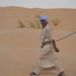 Le Sahara tunisien est une invitation à la découverte, à l'aventure et à l'émerveillement. Ce désert mythique, débordant de beauté naturelle et de mystère, est l'endroit idéal pour s'évader du quotidien et se reconnecter avec la nature. Si vous êtes en quête d'une expérience authentique, une excursion dans le Sahara tunisien est la promesse d'une aventure unique que vous ne trouverez nulle part ailleurs. Voici tout ce que vous devez savoir pour planifier votre circuit dans le désert du Sud tunisien. Pourquoi Choisir le Sahara Tunisien pour Votre Prochaine Aventure ? Avec ses dunes dorées, ses oasis verdoyantes et ses villages pittoresques, le Sahara tunisien offre une richesse paysagère que peu d'autres déserts peuvent égaler. Ici, chaque coin du désert vous révèle un pan de l'histoire et de la culture tunisienne. Que ce soit pour une balade en chameau, une nuit sous les étoiles, ou une visite des villages berbères, le Sahara est une porte ouverte vers un monde où le temps semble s'arrêter. Imaginez-vous traversant les dunes en voiture 4x4, découvrant des oasis cachées comme Chebika et Tamerza, ou explorant les vestiges historiques de Tatouine, rendus célèbres par leur apparition dans les films de Star Wars. Le Sahara tunisien est un terrain de jeu immense pour les amateurs d'aventure, mais aussi pour ceux qui préfèrent la détente et la contemplation. Les Incontournables d'un Circuit dans le Sud Tunisien 1. Djerba : La Porte du Désert Djerba, la île des rêves, est souvent le point de départ des circuits dans le Sud tunisien. C'est une escale idéale pour se préparer à l'aventure saharienne tout en profitant des plages paradisiaques et des mémoires historiques de cette île charmante. La Ghriba, l'une des plus anciennes synagogues du monde, est un incontournable de l'île, tout comme les petits villages aux maisons blanches qui semblent tout droit sortis d'une carte postale. 2. Tatouine : Sur les Traces des Berbères Pour les amateurs d'histoire et de culture, la région de Tatouine est une étape incontournable. Ce village est entouré de ksours, ces forteresses berbères qui servaient à entreposer les récoltes et protéger la population. En arpentant les ruelles, vous pourrez ressentir l'énergie des anciens habitants, et découvrir les gorges de Douiret, offrant des vues panoramiques à couper le souffle. Le nom de Tatouine a aussi été popularisé par la saga Star Wars, car plusieurs scènes y ont été tournées. Si vous êtes un fan de la saga, une visite des lieux de tournage est une étape obligatoire. Pour plus d'informations et pour organiser un circuit désert, rendez-vous sur le site officiel. 3. Douz : La "Porte du Sahara" Douz, souvent surnommée la "Porte du Sahara", est l'endroit parfait pour se lancer dans le désert. Ici, la tradition est encore vivante, et chaque coin de rue respire la culture saharienne. Douz est le point de départ de nombreuses excursions à dos de chameau. Se perdre dans l'immensité des dunes est une expérience inégalable, permettant de découvrir le désert sous un autre jour, loin du tumulte de la ville. Ne manquez pas le marché de Douz, un endroit où les produits locaux et les souvenirs traditionnels abondent. Vous pourrez y trouver des tapis berbères, des bijoux artisanaux, et bien sûr, les fameuses dattes Deglet Nour, véritable trésor du désert. 4. Matmata : Le Village Troglodyte Matmata est l'une des destinations les plus emblématiques du Sud tunisien, notamment pour ses maisons troglodytes. Ces habitations, creusées directement dans la roche, permettent de se protéger de la chaleur écrasante du désert. Une visite de Matmata est une plongée dans un univers où l'homme a su s'adapter aux contraintes de la nature. Les amateurs de cinéma y reconnaîtront aussi la maison de Luke Skywalker dans Star Wars. Mais au-delà de l'aspect cinématographique, Matmata est un lieu fascinant pour comprendre comment les Berbères ont su s'approprier un environnement aussi hostile. L'Expérience Unique d'une Nuit sous le Ciel du Sahara Passer une nuit dans le désert est probablement l'une des expériences les plus magiques qu'offre un circuit dans le Sahara tunisien. Imaginez-vous autour d'un feu de camp, le ciel constellé d'étoiles, écoutant les histoires des guides berbères, tout en savourant un dîner traditionnel à base de couscous ou de tajine. Les campements, souvent équipés de tentes confortables, permettent de vivre l'aventure du désert tout en étant bien installé. Et le matin, se réveiller au son du vent parmi les dunes et admirer le lever du soleil sur le sable doré est une vision qui restera gravée dans votre mémoire pour toujours. Les Montagnes de Chebika et Tamerza : Un Paradis Caché L'oasis de Chebika et les montagnes de Tamerza sont parmi les merveilles les plus surprenantes du Sahara tunisien. Ces oasis de montagne, avec leurs cascades et leurs palmiers, offrent un contraste saisissant avec l'aridité du désert environnant. Une randonnée dans ces oasis est une excellente façon de découvrir la faune et la flore locales, et de comprendre comment la vie s'organise dans ces endroits reculés. L'eau cristalline des cascades de Tamerza est idéale pour se rafraîchir après une longue journée d'exploration dans le désert. Chebika, surnommée la "Qasr el-Chébika", était autrefois un poste romain avant de devenir un refuge berbère. Aujourd'hui, il offre une vue imprenable sur les montagnes environnantes et la vallée, qui s'étend à perte de vue. Quand Partir en Excursion dans le Sahara Tunisien ? Le Sahara tunisien est un lieu magique à toute saison, mais pour une expérience optimale, il est recommandé de prévoir votre circuit entre octobre et avril. Les températures y sont plus douces, permettant de profiter pleinement des différentes activités, qu'il s'agisse de balades en chameau, de randonnées dans les montagnes ou de nuits à la belle étoile. L'été peut être très chaud, avec des températures qui atteignent facilement les 45 à 50 degrés Celsius, ce qui rend les activités physiques plus difficiles à supporter. Toutefois, si vous êtes prêts à affronter la chaleur, l'été offre également un paysage unique avec des dunes dorées sous un soleil intense. Organiser Votre Circuit dans le Sahara Tunisien Pour organiser votre excursion dans le Sahara tunisien, nous vous recommandons de faire appel à des guides locaux expérimentés. Ces derniers connaissent parfaitement le terrain et sauront vous faire vivre une expérience authentique et sécurisée. Que vous préfériez une balade en chameau, une randonnée en 4x4, ou une nuit en bivouac, les possibilités sont infinies pour adapter votre aventure à vos envies. Pour ceux qui souhaitent une expérience sur mesure, il est possible de concevoir un circuit privé, avec des étapes choisies selon vos préférences. Vous pouvez d'ailleurs obtenir un devis pour organiser votre voyage sur le site SudTunisie. Conclusion : Vivez l'Expérience Unique du Sahara Tunisien Le Sahara tunisien est bien plus qu'un simple désert. C'est un lieu où le temps semble s'être arrêté, où chaque dune, chaque oasis, et chaque village raconte une histoire. En choisissant un circuit dans le Sud tunisien, vous vous offrez la possibilité de vivre une aventure unique, à la rencontre de paysages à couper le souffle et d'une culture riche et authentique. Que vous soyez en quête d'aventure, de détente, ou de découverte culturelle, le Sahara tunisien a quelque chose à vous offrir. Venez explorer ses dunes infinies, ses oasis cachées, et laissez-vous envoûter par la magie du désert.