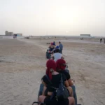 Un aperçu du Sud Tunisien et de ses Paysages Authentiques Nous souhaitons vous emmener bien au-delà des images de cartes postales, afin de vous plonger dans l’univers fascinant du Sud tunisien. Cette région, souvent considérée comme la porte d’entrée du Sahara, est dotée d’un riche patrimoine naturel et culturel. Ici, chaque journée de vacances peut devenir une aventure aux multiples facettes, qu’il s’agisse de chevaucher un chameau à travers les dunes dorées, de parcourir un marché local en quête d’épices parfumées, ou de profiter d’un moment de calme au bord d’une oasis idyllique. Le Sud tunisien est un territoire où les traditions berbères s’expriment au détour d’un village troglodyte, où les influences arabes, africaines et méditerranéennes se mêlent avec subtilité, et où la gastronomie rappelle l’importance de l’hospitalité. En optant pour une excursion et circuit vacances Sud Tunisien, vous vous offrez la possibilité d’explorer des lieux qui sortent des sentiers battus, loin de l’agitation urbaine. Ici, les couleurs, les sons et les odeurs créent une toile unique. Au fil des kilomètres, entre déserts, palmeraies et montagnes rocheuses, nous découvrons une variété de panoramas à couper le souffle. Les dunes offrent une palette de tons allant du beige pâle au rouge cuivré, tandis que les oasis, véritables joyaux verts, abritent des jardins luxuriants et des points d’eau rafraîchissants. Les villages berbères, nichés dans des reliefs escarpés, témoignent quant à eux du caractère profondément enraciné de cette culture ancestrale. Choisir un Circuit Authentique : Entre Dunes, Oasis et Rencontres Locales Pour vivre une expérience qui dépasse la simple promenade touristique, choisir un circuit authentique est essentiel. Nous vous conseillons de privilégier des itinéraires conçus par des experts locaux, capables de vous montrer les multiples visages du Sud tunisien. Certains parcours, tels que ceux proposés sur le site dédié aux circuits désert, permettent de survoler l’essentiel en combinant visites historiques, découvertes culturelles et immersion dans le désert. D’autres circuits se concentrent plutôt sur la détente, le bien-être et la rencontre avec les habitants, tandis que certains mettent l’accent sur la photographie, la randonnée ou l’exploration plus sportive. Il est possible de s’aventurer vers Douz, considérée comme la « porte du Sahara », où se tient un marché hebdomadaire animé et coloré. De là, une chevauchée à dos de chameau ou en 4x4 tout-terrain vous mènera au cœur des dunes de l’erg, idéales pour contempler un coucher de soleil aux nuances de rose, d’orange et de violet, un moment magique dont la beauté paisible reste gravée en mémoire. Les amateurs d’histoire apprécieront un détour par Matmata, connue pour ses maisons troglodytes, où l’architecture creusée dans la roche offre un contraste saisissant avec les étendues désertiques environnantes. Les plus curieux pourront s’arrêter dans des villages semi-nomades, où un accueil chaleureux et des sourires complices témoignent de la générosité des habitants. Lorsque nous évoquons un circuit authentique, il s’agit non seulement de découvrir des lieux, mais aussi de vivre des instants de partage. En dialoguant avec les artisans locaux, on comprend mieux la valeur de leurs créations, qu’il s’agisse de tapis tissés à la main, de poteries fines ou de bijoux en argent ciselé. Ces rencontres offrent l’opportunité de goûter à la sincérité et à la gentillesse des populations locales, prêtes à vous renseigner sur leurs coutumes, leurs plats typiques ou encore leurs croyances liées au désert. Expéditions dans le Désert : Naviguer au Cœur du Sahara Un voyage dans le Sud tunisien ne serait pas complet sans une véritable immersion dans le Sahara, ce vaste océan de sable aux reflets changeants. Explorer le désert, c’est s’ouvrir à une expérience sensorielle hors du commun. Le silence saisissant qui règne entre les dunes, la lumière qui joue avec les ombres, le crissement des pas sur le sable, tout cela façonne une atmosphère presque mystique. Nous vous recommandons fortement de passer au moins une nuit dans le désert, sous une tente berbère, afin de contempler la voûte étoilée dans toute sa splendeur. Sans pollution lumineuse, les constellations semblent plus brillantes, et la Voie lactée déroule un spectacle à couper le souffle. Les plus aventureux pourront opter pour une randonnée chamelière de plusieurs jours à travers les dunes, un périple ponctué d’arrêts dans des campements éphémères. D’autres préféreront le confort d’un 4x4, permettant d’atteindre des points de vue reculés, des lacs salés comme le Chott el-Jérid, ou des zones où la faune et la flore se révèlent étonnamment variées. Le désert tunisien abrite en effet de nombreuses espèces animales, notamment des fennecs, des gerboises ou encore des reptiles parfaitement adaptés à cet environnement extrême. Les plantes qui poussent dans ces conditions difficiles sont également remarquables : acacias, tamaris et herbes sahariennes témoignent d’une résilience fascinante. Pour qui s’intéresse à la culture locale, une balade dans le Sahara est aussi l’occasion de mieux comprendre le mode de vie des nomades et la façon dont ils préservent leurs traditions. Les légendes de caravaniers, transmises de génération en génération, résonnent entre les dunes. Vous pourrez peut-être assister à des soirées autour du feu, où l’on partage du thé à la menthe dans une ambiance conviviale, bercé par les notes d’un oud ou d’un bendir. Ce sont des instants simples, mais profondément marquants, qui donnent toute sa valeur à un circuit dans le Sud tunisien. Activités Culturelles et Rencontres Locales : Plonger au Cœur des Traditions Le Sud tunisien est un véritable livre d’histoires, dont les pages s’animent au détour d’une ruelle, d’un café ou d’un marché. Nous suggérons d’inclure au programme de vos vacances des étapes plus culturelles. La visite de médinas anciennes, de ksours fortifiés et de villages berbères permet de comprendre le lien fort qui unit les populations à leur terre. Les échanges avec des familles locales, l’apprentissage de quelques mots d’arabe ou de berbère, ou encore la dégustation d’un plat fait maison renforcent la dimension humaine du voyage. Assistez à des ateliers artisanaux pour découvrir les secrets du tissage, de la poterie ou de la calligraphie. Participez à la récolte des dattes dans une palmeraie. Visitez des greniers collectifs (les ksour), ces structures impressionnantes qui servaient autrefois à stocker les récoltes et à protéger les biens de la communauté. Leur architecture ingénieuse surprend, et l’on saisit alors l’importance de l’entraide dans un environnement où les ressources sont limitées. Au fil des conversations, vous apprendrez les liens étroits qui unissent musique, danse et tradition orale dans cette région. Les fêtes et les mariages sont souvent animés par des danses folkloriques et des chants transmis de génération en génération, illustrant la richesse du patrimoine culturel. Découvrir le Sud tunisien de cette façon, c’est se donner la chance de créer des liens sincères et durables avec une terre et un peuple qui, bien souvent, accueillent les voyageurs avec une générosité teintée de fierté. Gastronomie et Saveurs Locales : Un Festival pour les Papilles La cuisine du Sud tunisien est un reflet sincère de son identité. Elle est simple, nourrissante, et fondée sur des produits frais et locaux. Les saveurs s’expriment dans des plats typiques que nous vous encourageons vivement à déguster. Le couscous, par exemple, varie selon les régions et les familles. Parfois parfumé aux herbes, parfois agrémenté de légumes du désert et de viande de mouton, il constitue un repas convivial et rassasiant. Les soupes parfumées (chorba), les plats mijotés comme le tajine tunisien, et les galettes de pain cuites sur des pierres chaudes sont autant de spécialités qui révèlent la créativité gastronomique de ce terroir. Les épices jouent un rôle crucial dans l’équilibre des saveurs. Cumin, coriandre, carvi, paprika et harissa, cette pâte de piment emblématique de la Tunisie, colorent et pimentent les préparations culinaires. Les dattes, omniprésentes dans cette région, sont un délice à elles seules, qu’elles soient dégustées fraîches, séchées ou transformées en pâtisseries sucrées. Les fruits secs, le miel et l’huile d’olive locale complètent ce tableau gastronomique. Nous vous conseillons également d’essayer les boissons traditionnelles, comme le thé à la menthe ou le café aux épices, pour un moment de détente après une journée d’exploration. Au-delà de la simple dégustation, la gastronomie du Sud tunisien est une invitation à partager. Manger ensemble, échanger, comparer les recettes, en apprendre plus sur les coutumes culinaires locales, voilà ce qui donne à l’expérience une saveur encore plus authentique. Les restaurants familiaux, les campements dans le désert ou les maisons d’hôtes vous offriront l’opportunité de goûter des mets préparés avec passion, souvent selon des méthodes transmises de père en fils ou de mère en fille. Conseils Pratiques pour un Séjour Inoubliable dans le Sud Tunisien Pour profiter pleinement d’un circuit dans le Sud tunisien, quelques conseils pratiques s’imposent. Le climat du désert est caractérisé par de fortes amplitudes thermiques : les journées peuvent être chaudes et ensoleillées, tandis que les nuits sont parfois fraîches. Nous vous recommandons donc d’emporter des vêtements légers, mais aussi une veste ou une couverture pour les soirées. Un chapeau, des lunettes de soleil et de la crème solaire protègent efficacement contre le rayonnement intense, et prévoir des chaussures fermées facilite les randonnées dans le sable. En termes de logistique, il est conseillé de bien préparer son itinéraire, de réserver son circuit auprès de prestataires fiables, et de s’informer sur les formalités administratives (visa, passeport en cours de validité). Le Sud tunisien est généralement sûr, mais comme partout, la vigilance est de mise. L’hydratation est primordiale : boire suffisamment d’eau permet de profiter pleinement du voyage sans subir la fatigue liée à la chaleur. Pour prolonger l’expérience, rien ne vaut l’assistance d’experts locaux. Qu’il s’agisse de choisir un itinéraire, de découvrir des adresses confidentielles ou de dénicher des activités insolites, faire appel à des guides expérimentés assure un séjour sans accroc. Ces professionnels connaissent le désert et les régions qui l’entourent, sont capables d’adapter le programme selon vos envies, et de rendre votre séjour aussi personnalisé que possible. Pour toute demande de devis ou d’informations complémentaires, vous pouvez consulter cette page de contact et de voyage sur mesure. Préparer Son Voyage dès Maintenant : Entre Anticipation et Flexibilité Se lancer dans une excursion et circuit vacances Sud Tunisien se prépare en amont. Nous vous suggérons de prendre le temps de réfléchir à vos priorités : souhaitez-vous privilégier les découvertes culturelles, l’aventure en plein désert, ou au contraire la détente dans un campement confortable ? Il est également conseillé de s’informer sur les périodes les plus propices pour visiter la région. Le printemps et l’automne sont souvent des saisons idéales, offrant un climat plus doux et une fréquentation touristique plus modérée. Au-delà de ces considérations, l’important est de se montrer flexible. Le désert, comme la mer, aime surprendre : un ciel nuageux peut donner lieu à un coucher de soleil spectaculaire, tandis qu’un vent inattendu peut sculpter des dunes éphémères. S’ouvrir à l’imprévu est souvent la clé pour apprécier pleinement ce voyage. Le Sud tunisien est une région qui dévoile ses richesses à ceux qui savent prendre leur temps, écouter et observer. Au fil des journées, vous comprendrez mieux comment les éléments naturels ont façonné les paysages, la vie des habitants et leurs traditions. Vous quitterez ce coin de Tunisie avec le sentiment d’avoir touché du doigt une authenticité rare, d’avoir vécu une aventure marquante, riche d’émotions, de saveurs et de rencontres. Chaque souvenir, chaque sensation, chaque rencontre viendra nourrir votre imaginaire et, sans doute, éveiller le désir de revenir un jour fouler ces étendues infinies de sable.