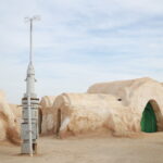 Et si, cette année, vous décidiez de terminer l’année sous le ciel infini du Sahara tunisien, entre dunes dorées, feu de camp et ambiance conviviale ? Oubliez les soirées de réveillon classiques et laissez place à une aventure authentique au cœur du désert. Chez Sud Tunisie, nous vous invitons à vivre un circuit exceptionnel dans le Sud tunisien, spécialement conçu pour célébrer la fête de fin d’année dans le Sahara de la manière la plus mémorable qui soit. Découvrez dès maintenant nos programmes exclusifs ici : circuits désert Sahara Tunisie Une expérience inoubliable : fêter la nouvelle année dans le Sahara tunisien Il n’y a rien de plus magique que de passer le réveillon du Nouvel An sous les étoiles du Sahara. Imaginez un silence apaisant, brisé seulement par le vent qui caresse les dunes, un feu de camp crépitant et un dîner berbère aux saveurs du Sud. Le Sahara tunisien est un lieu qui invite à la réflexion, à la détente et à la célébration. Ce voyage, c’est un moment d’évasion loin du tumulte urbain, une immersion dans la culture tunisienne la plus pure. De Douz à Ksar Ghilane, en passant par Tozeur, Matmata ou Tataouine, chaque étape est une nouvelle découverte, une émotion différente. Et le soir du réveillon ? C’est un spectacle à ciel ouvert. Le désert s’illumine sous la lune, les tambours résonnent, le thé à la menthe coule à flot, et l’on se laisse porter par l’ambiance magique du Sahara. Un circuit complet à la découverte du Sud tunisien Nos circuits de fin d’année combinent aventure, nature, culture et détente. Voici un aperçu du parcours que nous proposons pour vivre pleinement cette expérience saharienne. 1. Tozeur – L’oasis de charme et porte du désert Votre aventure débute à Tozeur, l’une des plus belles oasis du Maghreb. Ici, les palmiers dattiers s’étendent à perte de vue, formant un véritable écrin de verdure. Vous découvrirez la médina typique aux murs de briques ocre, le musée Dar Cheraït et les célèbres oasis de montagne : Chebika, Tamerza et Mides, véritables joyaux suspendus entre falaises et cascades. Pour les amateurs de nature et d’effort doux, découvrez aussi nos programmes de randonnée en montagne dans le Sahara . 2. Douz – La porte du Sahara Douz, surnommée la porte du désert, marque le début du grand voyage à travers les dunes. Vous monterez sur le dos d’un dromadaire pour une balade silencieuse à travers le sable chaud, avant de rejoindre un campement saharien pour la nuit. Là, autour du feu, vous goûterez le pain traditionnel cuit sous le sable, échangerez avec les nomades et admirerez le ciel étoilé comme vous ne l’avez jamais vu. 3. Ksar Ghilane – L’oasis des aventuriers C’est à Ksar Ghilane que la magie du réveillon opère. Cette oasis mythique, connue pour sa source d’eau chaude naturelle au milieu du désert, offre un cadre exceptionnel pour célébrer la nouvelle année. Au programme : bain thermal relaxant, balade en quad jusqu’au fort romain de Tisavar, et surtout, soirée de réveillon saharienne sous tente. Musique, danse, dîner berbère et feu de camp rythment la nuit. 4. Matmata – Les maisons troglodytiques et le charme berbère Après la fête, direction Matmata, célèbre pour ses maisons creusées dans la roche, un style architectural ancestral unique. Ce décor impressionnant a même inspiré les réalisateurs de Star Wars. Vous serez accueillis par une famille locale qui vous fera déguster un déjeuner typiquement berbère. 5. Tataouine et les ksours du désert Le circuit se poursuit vers Tataouine, région emblématique du sud tunisien. Vous y découvrirez les ksours, anciens greniers fortifiés berbères tels que Ksar Ouled Soltane ou Chenini, véritables témoignages d’un passé riche et mystérieux. Un réveillon magique : entre dunes, musique et traditions Passer le réveillon du Nouvel An dans le désert tunisien, c’est vivre un moment d’exception. Les festivités commencent dès la fin d’après-midi, avec un apéritif au coucher du soleil. Ensuite, les convives se rassemblent sous une grande tente, décorée de tapis traditionnels et de lanternes, pour partager un repas de fête aux saveurs sahariennes : méchoui, couscous d’agneau, dattes de Tozeur, pâtisseries orientales et thé à la menthe. Puis, place à la musique ! Des groupes folkloriques animent la soirée avec des rythmes de tambours, de derbouka et de flûte. L’ambiance est à la joie, aux rires et à la danse. À minuit, le désert devient silencieux un instant… avant de laisser place aux cris de joie et à la beauté d’un ciel étoilé d’une pureté rare. 👉 Réservez votre réveillon magique dans le Sahara ici : demande de devis gratuit Des excursions et activités pour prolonger le rêve Le Sud tunisien ne se résume pas qu’au désert : il regorge d’expériences uniques à vivre avant ou après votre circuit. Découvrez nos suggestions d’excursions et d’activités complémentaires : Balade en quad ou en buggy dans les dunes Visite des oasis de montagne de Tozeur et Tamerza Randonnée dans le désert avec nuit en bivouac Découverte des ksours et villages berbères Visite du Chott El Jerid, le plus grand lac salé de Tunisie 👉 Consultez toutes nos offres d’excursion en Tunisie et inspirez-vous sur notre blog excursions Tunisie . Pour les voyageurs arrivant par avion, notre service de navette aéroport assure vos transferts en toute sérénité depuis Djerba, Tozeur ou Tunis : services navette aéroport . Nos circuits préférés pour la fin d’année Nous proposons plusieurs formules d’excursion et de circuit dans le Sahara tunisien, selon vos envies et la durée de votre séjour. Circuit 3 jours – Douz, Ksar Ghilane et Matmata Une immersion rapide mais complète dans le désert : balade à dos de dromadaire, bain thermal et nuit sous tente à Ksar Ghilane. Circuit 4 jours – Tozeur, Douz, Matmata et Tataouine Ce programme allie découverte culturelle et paysages variés : oasis, montagnes, dunes et villages berbères. Circuit 5 jours – Le grand Sud tunisien Pour une expérience totale, ce circuit traverse Tozeur, Douz, Ksar Ghilane, Matmata et Chenini, avec réveillon festif et hébergement authentique. Découvrez le détail complet ici : circuits désert Sahara Tunisie . Des services sur mesure et une organisation irréprochable Chez Sud Tunisie, notre priorité est de vous offrir une expérience sans souci, de la réservation à votre retour. Nos circuits incluent : Le transport en véhicules 4x4 confortables et climatisés L’hébergement en hôtels, lodges ou bivouacs sahariens La restauration complète avec menus locaux L’accompagnement par des guides expérimentés L’assistance personnalisée avant et pendant votre séjour Chaque détail est pensé pour que vous profitiez pleinement du moment. Et si vous souhaitez une formule sur mesure, notre équipe est à votre écoute : demande de devis gratuit . Témoignages et avis de voyageurs Nos clients décrivent leur séjour dans le Sahara comme l’une des plus belles expériences de leur vie. “Un réveillon inoubliable au cœur du désert ! L’équipe de Sud Tunisie était aux petits soins, tout était parfaitement organisé.” – Sophie, France “Voir le lever du soleil sur les dunes après une nuit sous tente… magique !” – Rachid, Suisse Retrouvez d’autres témoignages sur notre page : avis clients Sud Tunisie sur TripAdvisor Préparez dès maintenant votre réveillon saharien Les places pour nos circuits de fin d’année dans le Sahara tunisien sont limitées. C’est une aventure qui attire chaque année des voyageurs venus du monde entier, en quête d’authenticité et de déconnexion. 👉 Réservez votre place dès maintenant : Circuits désert Sahara Tunisie Randonnée montagne Sahara Excursion en Tunisie Blog excursions Tunisie Service navette aéroport Devis gratuit Conclusion – Un Nouvel An pas comme les autres Fêter le Nouvel An dans le Sahara du sud tunisien, c’est bien plus qu’un simple voyage : c’est une expérience humaine, spirituelle et sensorielle. Sous un ciel étoilé d’une clarté absolue, le temps semble suspendu. Le désert, immense et silencieux, nous invite à célébrer la vie autrement, dans la simplicité et la beauté. Cette année, laissez tomber les soirées bruyantes et les artifices. Offrez-vous un réveillon magique sous les étoiles du Sahara, et commencez la nouvelle année avec des souvenirs impérissables.