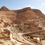 Quand on pense au Sud tunisien, on imagine tout de suite les cordons de dunes dorées, les oasis aux palmiers généreux, les villages troglodytes, les ksour perchés et ces routes mythiques qui filent vers l’infini. Nous organisons des circuits et excursions sur mesure dans le Sud de la Tunisie, avec un vrai sens du détail : transport ponctuel façon « UBER local » (navettes privées, transferts porte-à-porte), guides passionnés, hébergements authentiques et activités adaptées à votre rythme. Que vous partiez de Tunis, Hammamet, Sousse, Monastir, Sfax, Djerba, Gabès, Bizerte, Kélibia ou Korba, notre équipe coordonne chaque étape pour que vous n’ayez qu’une seule chose à faire : profiter. Les points forts d’un circuit Sahara conçu pour vous Un bon itinéraire se reconnaît à sa fluidité. Nous bâtissons nos circuits en partant de vos contraintes (dates, aéroports, niveau de confort, budget) et de vos envies (désert total, culture et archéologie, adrénaline 4×4, randonnée, slow travel…). Voici ce qui fait la différence : Transferts privés et ponctuels dès votre arrivée, avec accueil personnalisé et suivi de vol. Pour vos arrivées/départs, facilitez-vous la vie grâce à notre service de navette aéroport : voir nos navettes . Véhicules adaptés : berlines confort, vans pour familles, 4×4 climatisés pour les pistes sablonneuses. Guides locaux francophones fin connaisseurs du territoire : légendes du Chott el-Jérid, savoir-faire des nomades, flore et faune du désert, repérages cinéma (Star Wars et décors naturels). Hébergements de caractère : maisons d’hôtes, campements bédouins, hôtels de charme en oasis. Rythme maîtrisé : pas de course contre la montre, on ménage du temps pour la lumière du soir, les couchers de soleil, les pauses photo et les marchés. Expériences immersives : thé à la menthe sous la tente, dégustation de dattes Deglet Nour, atelier de cuisine du désert, balade à dos de dromadaire au crépuscule. Pour explorer nos propositions de circuits désert, consultez notre page dédiée : circuits Sahara & grands itinéraires . Si vous préférez une évasion à la journée ou 2-3 jours, misez sur une excursion en Tunisie souple et efficace : nos excursions . Les amateurs d’outdoor adoreront nos randonnées en montagne et Sahara : partir en randonnée . Et pour l’inspiration, un coup d’œil à notre blog d’excursions : lire le blog . Idées d’itinéraires : du premier contact avec les dunes à l’expédition saharienne Nous structurons les itinéraires autour de « thèmes » pour que chaque voyage ait une identité claire. Voici des exemples modulables selon la durée et votre point de départ : Tunis, Hammamet, Sousse, Monastir, Sfax, Djerba, Gabès, Bizerte, Kélibia, Korba. H2 — “Premiers pas dans le Sahara” : 3 jours entre Tozeur et Douz Jour 1 : Tozeur & Chott el-Jérid — Arrivée, transfert privé, visite de l’oasis et des quartiers en briques de sel, traversée du lac salé pour capter ces reflets surréalistes. Coucher de soleil sur une mer blanche craquelée : magique. Jour 2 : Montagnes de Tamerza & Chebika — Cascades rafraîchissantes, canyons ocres, vues panoramiques. Déjeuner dans un village de montagne et retour via Mides par une route sinueuse à couper le souffle. Jour 3 : Douz, porte du désert — Cap sur Douz, approche douce du désert : mini-trek sur les dunes, dromadaire au soleil couchant, dîner typique sous tente. Envie d’ajouter une nuit en bivouac ? Nous prévoyons un campement nomade avec feu de camp et étoiles plein ciel. Pour un devis immédiat : demander un devis gratuit . H2 — “Grand Sud et ksour” : 5 jours via Matmata & Tataouine Jour 1 : Djerba – Médenine – Tataouine — Mosquées blanches et vieux ksour (greniers collectifs). Nuit en maison d’hôtes. Jour 2 : Ksar Ouled Soltane & Chenini — Architecture berbère, panoramas infinis. Déjeuner chez l’habitant pour goûter la vraie cuisine du Sud. Jour 3 : Matmata troglodyte — Demeures creusées dans la roche, espaces frais et silencieux. Atelier photo au golden hour. Jour 4 : Ksar Ghilane — Oasis au milieu du sable : sources chaudes, quad optionnel, 4×4 jusqu’à un petit fort abandonné. Nuit en campement. Jour 5 : Douz ou Djerba — Retour en douceur, halte dattes & artisanat. H2 — “Expédition saharienne” : 7–9 jours en immersion 4×4 Tozeur – Tembaine – Ksar Ghilane – Zmela – Douz — On enchaîne piste, ergs et regs, avec navigation en 4×4, campements successifs, cuisine au feu, observation du ciel profond et réveils au silence absolu. Modules randonnée : sections à pied de 2–5 heures pour sentir le sable, apprendre à lire le relief, comprendre le vent et l’orientation. Culture vivante : halte dans des ksour habités, café sous la tente, fabrication du pain de sable. Pour une vision d’ensemble et inspirer votre propre itinéraire, parcourez nos circuits désert : voir les circuits . Excursions à la journée ou 2–3 jours : efficacité, confort, souvenirs Parfaites si vous avez peu de temps ou si vous souhaitez « goûter » au Sud avant un road trip plus long. Nous proposons des excursions au départ de Tunis, Hammamet, Sousse, Monastir, Sfax, Djerba, Gabès, Bizerte, Kélibia, Korba : Tozeur & oases de montagne : Chebika, Tamerza, Mides en une journée bien rythmée. Douz & dromadaire : initiation aux dunes, coucher de soleil, dîner nomade. Matmata troglodyte : immersion chez l’habitant, déjeuner traditionnel. Ksar Ghilane Express : baignade dans la source, quad optionnel, 4×4 vers le fort. Réservez facilement votre excursion en Tunisie : toutes nos excursions . Envie d’une randonnée plus sportive ? C’est par ici : randonnée montagne & Sahara . Transports et navettes “type UBER” : ponctualité, sécurité, sérénité Nous assurons vos transferts privés entre les grandes villes et les portes du Sahara (Tozeur, Douz, Tataouine, Matmata, Ksar Ghilane…). Notre service de navette aéroport fonctionne 7 j/7, tôt le matin et tard le soir, suivi en temps réel des arrivées et trajets : Prise en charge à l’aéroport, à votre hôtel ou à domicile. Véhicules récents : confort, climatisation, sièges enfant sur demande. Chauffeurs professionnels maîtrisant les itinéraires rapides et les haltes photo. Pour en savoir plus ou planifier votre arrivée : navettes aéroport . Quand partir et combien de jours prévoir ? Octobre → mai : la période idéale pour la lumière, des températures douces et ciel dégagé. Été : circuits adaptés (départs tôt, pauses fraîches, hébergements climatisés). Durée : 3–4 jours pour un condensé Sahara + oasis, 5–6 jours pour ksour & troglodytes, 7–9 jours pour la grande immersion en 4×4 avec bivouacs. Astuce : laissez-vous un après-midi libre en oasis pour reprendre souffle et flâner sur les marchés. Explorez nos idées et variantes : circuits désert personnalisables . Où dormir ? Campements, maisons d’hôtes, hôtels de charme Nous sélectionnons des hébergements qui racontent le territoire : Campement saharien : tentes privatives, dîner au feu de bois, ciel étoilé irréel. Maison d’hôtes : accueil familial, cuisine locale, patios ombragés. Hôtel de charme : confort moderne, piscine, spa lorsque disponible. Chaque nuit a un sens dans l’itinéraire (proximité d’un site, qualité du ciel nocturne, ambiance village, authenticité). Les retours de nos voyageurs sont consultables ici : avis clients sur Tripadvisor : lire les avis . Activités signature : vivre le désert, pas seulement le regarder Randonnée crêtes de dunes (2–4 h) : comprendre le vent, suivre les lignes, sentir l’élasticité du sable. → Nos randonnées . Dromadaire au coucher du soleil : le rythme millénaire de la caravane, parfait pour les photos. 4×4 sur erg (piloté par nos chauffeurs) : franchissements maîtrisés, sécurité et adrénaline juste ce qu’il faut. Atelier cuisine nomade : pain de sable, méchoui, couscous de l’oasis. Rencontres : café sous la tente, artisans des ksour, récolte des dattes (selon saison). Photographie : le Chott comme miroir, canyons ocre, portes bleues des villages, ciel nocturne d’une pureté rare. Envie d’un format court et efficace ? Consultez nos excursions : voir les excursions . Pour une exploration plus ample : circuits désert . Départs garantis et villes de prise en charge Nous organisons vos départs depuis : Tunis, Hammamet, Sousse, Monastir, Sfax, Djerba, Gabès, Bizerte, Kélibia, Korba. L’avantage : pas besoin de vous adapter à un point de rendez-vous imposé. Nous venons où vous êtes, y compris à l’aéroport, en hôtel ou location saisonnière. Besoin d’une prise en charge multi-villes (ex. Tunis à l’aller, Djerba au retour) ? Nous le prévoyons dès la conception de votre itinéraire. Demandez votre devis gratuit en 1 minute : formulaire de devis . Combien ça coûte ? Transparence et options Le tarif dépend de : la durée, la saison, le niveau d’hébergement, le nombre de participants, les activités (quad, dromadaire, spa) et les transferts. Pour les courts séjours, l’excursion offre un excellent rapport valeur/temps. Pour l’immersion, le circuit désert reste imbattable. Nous détaillons toujours ce qui est inclus (transports, guide, hébergements, certains repas, activités) et ce qui ne l’est pas (vols, pourboires, dépenses personnelles). Consultez nos circuits pour visualiser les combinaisons possibles : voir les circuits désert , ou contactez-nous pour un devis sur mesure : demander un devis . Family-friendly, couple ou entre amis : un Sahara pour chacun En famille : trajets fractionnés, haltes régulières, hébergements adaptés, ateliers ludiques (étoiles, pain de sable). En couple : bivouac premium, dîners privés, coucher de soleil sur l’erg, spa en oasis. Entre amis : 4×4, quad, randonnée sportive, sessions photo et couchers de soleil intenses. Solo : départs à dates flexibles, accompagnement rapproché, rythme personnalisé. Pour puiser des idées et retours d’expérience, parcourez notre blog : conseils & récits d’excursions . Conseils pratiques : préparer et réussir son circuit Tenue : couches légères, coupe-vent, chèche ou casquette, chaussures fermées. Soleil & hydratation : lunettes UV, crème, gourde réutilisable. Sacs : un petit sac de jour pour eau, appareil photo, coupe-vent. Photo : filtres pour hautes lumières au Chott, batterie de rechange. Respect : villages, souks, lieux de culte : demander avant de photographier. Saisons : nuits plus fraîches en hiver ; prévoir une polaire pour les bivouacs. Besoin d’un récap’ adapté à votre période de voyage ? Contactez-nous : devis & contact . Pourquoi nous faire confiance ? Logistique soignée : transferts “à la minute”, hébergements testés, restos choisis pour leur qualité. Ancrage local : retombées pour les communautés, circuits co-construits avec des artisans et familles. Sécurité : briefings, véhicules entretenus, itinéraires validés, alternatives en cas d’imprévu. Flexibilité : un programme reste un cadre, pas une contrainte ; on ajuste sur place selon vos envies et la lumière. Les témoignages de voyageurs sont publics : avis clients : lire les avis sur Tripadvisor . FAQ — Circuits et excursions UBER Sud Tunisie Combien de jours pour “bien voir” ? 4–5 jours suffisent pour un panorama oasis + dunes + ksour. En 7–9 jours, on s’offre l’expédition saharienne, avec bivouacs et pistes 4×4. D’où peut-on partir ? Nous organisons des départs depuis Tunis, Hammamet, Sousse, Monastir, Sfax, Djerba, Gabès, Bizerte, Kélibia, Korba. Départ aéroport ? Notre navette vous attend à la sortie. Faut-il être sportif ? Non. Nos circuits s’adaptent à votre forme. Les randonnées sont modulables : randonnée montagne & Sahara . Peut-on personnaliser à 100 % ? Oui. Durée, hébergements, activités, rythme : tout est ajustable. Voyez nos bases d’itinéraires : circuits désert . Et si je n’ai qu’une journée ? Optez pour nos excursions : idées d’excursions . Parfait pour un premier contact avec le Sahara. Comment réserver ? Remplissez le formulaire devis gratuit : devis & contact . Nous revenons vers vous rapidement avec une proposition claire. Passez à l’action : votre circuit Sahara commence ici Le Sahara tunisien n’est pas seulement un décor : c’est un rythme, une lumière, une rencontre. Pour vivre cette intensité sans contrainte, confiez-nous l’organisation de votre circuit et excursion UBER Sud Tunisie. Inspirez-vous de nos grands itinéraires : circuits désert . Explorez nos randonnées : montagnes & Sahara . Choisissez une excursion à la journée : toutes les excursions . Lisez notre blog pour préparer votre voyage : blog excursions Tunisie . Navettes aéroport et transferts privés : réserver une navette . Et surtout, obtenez votre devis gratuit en un clin d’œil : demander un devis . Nous avons hâte de vous accueillir dans le Sud tunisien, là où le désert raconte encore les plus belles histoires.
