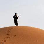 Le Sud tunisien est une promesse de contrastes : dunes blondes à perte de vue, oasis accroché aux falaises, villages troglodytiques sculptés dans la roche, ksour millénaires, lacs salés irisés… Ici, chaque virage ouvre une scène nouvelle. Nous créons des circuits et excursions au Sud tunisien, personnalisés dès votre porte : départ possible depuis l’adresse de votre choix en Tunisie (Tunis, Hammamet, Sousse, Monastir, Sfax, Gabès, Djerba, Tozeur, etc.). Qu’il s’agisse d’un mini-circuit de 2 jours/1 nuit ou d’une grande traversée saharienne de 8 jours et plus, nous ajustons le rythme, le confort et les étapes selon vos envies. Pour feuilleter nos itinéraires phares, découvrez la page dédiée aux circuits désert Sahara (à développer constamment avec de nouvelles idées). Pourquoi choisir un circuit au Sud tunisien ? Désert, oasis et ksour en une seule aventure Le Sud concentre tout ce qui fait la magie de la Tunisie : le Sahara vivant, les oasis de montagne (Chebika, Tamerza, Mides), le Chott el-Jérid scintillant, Matmata et ses maisons troglodytiques, Ksar Ghilane et sa source chaude, Tataouine et ses ksour (Chenini, Douiret, Ksar Ouled Soltane), sans oublier Ong Jmel et les décors de cinéma près de Tozeur. En quelques jours, vous traversez des paysages radicalement différents : salars blancs, canyons ocre, palmeraies suspendues, ergs dorés. Nous privilégions des groupes à taille humaine, une logistique souple et des rencontres authentiques : thé à la menthe chez un gardien de ksar, dégustation de Deglet Nour, ateliers d’artisan, moments silencieux au sommet d’une dune. Pour un aperçu global des possibilités et des dates, parcourez nos circuits désert et les excursions en Tunisie . Quand partir ? Meilleures périodes et météo saharienne Octobre → Avril : saison idéale du désert. Journées douces, nuits fraîches. Parfait pour enchaîner dunes, randonnées, bivouacs et visites culturelles. Mai & Septembre : périodes de transition. On avance tôt le matin, on multiplie les haltes à l’ombre et on prévoit des retours plus doux en fin d’après-midi. Juin → Août : chaleur marquée. Nous suggérons des programmes compacts, des hébergements climatisés et des activités à l’aube ou au crépuscule. Dans tous les cas, nos chauffeurs-guides adaptent les horaires au jour le jour pour optimiser confort, sécurité et lumière des paysages. Circuits personnalisés : 2 jours/1 nuit, 3–5 jours, 7–8 jours et plus Chaque voyage est modulable : départ depuis votre hôtel, maison ou aéroport (Tunis-Carthage, Enfidha, Monastir, Sfax, Djerba, Tozeur). Nous intégrons navette aéroport et transferts (infos : services de navette ) pour une arrivée sans stress. Mini-circuit 2 jours/1 nuit : premier souffle de Sahara Jour 1 : Départ – Douz – Dunes de l’Erg Prise en charge à l’adresse de votre choix. Halte à Douz, porte du désert : ajustement du cheich, petite initiation au sable, puis coucher de soleil sur l’erg. Dîner sous les étoiles, nuit en campement (confort) ou en bivouac nomade (immersif). Jour 2 : Balade chamelière – Ksar Ghilane (option) – Retour Balade à dos de dromadaire au lever du jour. Selon la saison, piste vers Ksar Ghilane et bain dans la source chaude. Retour en véhicule à votre adresse. Format express, parfait pour ressentir l’essentiel du désert quand le temps est compté. Circuit 3 jours/2 nuits : Douz – Ksar Ghilane – Matmata Jour 1 : Douz – Bivouac Traversée dunaire en 4×4 avec chauffeur-guide, installation du bivouac : tajine, méchoui, ciel constellé. Jour 2 : Ksar Ghilane – Tamezret – Matmata Bain en source chaude, piste panoramique vers Tamezret, visite de Matmata et de l’habitat troglodytique. Nuit en maison d’hôtes. Jour 3 : Plateaux lunaires – retour Haltes photo sur les tables rocailleuses, déjeuner local, retour. Circuit 5 jours : Tozeur – Chott el-Jérid – Ong Jmel – Oasis de montagne – Douz Jour 1 : Tozeur, vieille ville et palmeraie Balade à El-Hadef, briques ocres, calèche ou vélo dans la palmeraie. Jour 2 : Ong Jmel & décors de cinéma – Chott el-Jérid Dunes photogéniques, puis traversée du salar aux reflets rosés. Nuit à Douz. Jour 3 : Douz – Bivouac Plongée au cœur des dunes, feu de camp, pain cuit sous la cendre. Jour 4 : Chebika – Tamerza – Mides Oasis de montagne : oueds, cascades, canyon sculpté. Jour 5 : Tozeur Matinée libre : marché, dattes, musée (option). Grand circuit 7–8 jours : Des dunes aux ksour Parcours type : Tozeur – Douz – Ksar Ghilane – Tataouine – Chenini – Ksar Ouled Soltane – Matmata – Tozeur/Djerba/Tunis. Ce format multiplie ambiances et rencontres sans se presser : randonnées tranquilles, couchers de soleil, ateliers d’artisan, pauses thé à l’ombre d’un tamaris. Inspirez-vous de nos circuits désert à développer et demandez des variantes. Excursions à la journée : Chebika, Tamerza, Mides, Ong Jmel, Matmata, dromadaires à Douz Vous avez peu de temps ? Les excursions concentrent l’essentiel en quelques heures : Oasis de montagne (Chebika – Tamerza – Mides) : marche douce le long des oueds et points de vue vertigineux sur les palmeraies suspendues. Ong Jmel & décors du désert (près de Tozeur) : dunes ludiques, spots photo, sensations en 4×4. Matmata & Tamezret : immersion dans l’architecture troglodytique, déjeuner chakchouka, découverte de savoir-faire local. Douz au coucher du soleil : balade chamelière dorée, dîner méchoui ou brik à l’œuf. Parcourez la sélection et réservez facilement : Excursion en Tunisie . Et pour de l’inspiration régulière, consultez notre blog des excursions en Tunisie . Randonnée & trek : crêtes, oueds, dunes et nuits sous les étoiles Le Sud est un terrain de jeu incomparable pour la marche : crêtes tabulaires, couloirs sableux, canyons étroits, oueds ombragés. Nous concevons des boucles sur mesure, du familial au sportif : Randonnée de montagne & Sahara : alternance minérale/sable, panoramas grand angle, pauses contemplation. Bivouac nomade : tente légère, feu de camp, ciel profond et silence absolu. Logistique raisonnée : chameaux de bât ou véhicule d’assistance selon distance. Nos idées et check-lists d’équipement sont détaillées ici : Randonnée montagne – Sahara . Nos engagements : sécurité, confort, authenticité Sécurité : chauffeurs-guides expérimentés, suivi météo, itinéraires validés quotidiennement, pauses hydratation régulières, trousse de premiers secours, moyens de communication adaptés aux zones isolées. Confort modulable : du bivouac dépouillé au campement confort (lits, sanitaires) en passant par maisons d’hôtes et hôtels sélectionnés. Rythme souple : lever tôt pour la belle lumière, temps calme en milieu de journée, activités au crépuscule lorsque la température baisse. Cuisine locale : couscous, tajine, ojja, pain tabouna, dattes fraîches ; menus adaptés (végétarien, sans gluten, etc.) sur simple demande. Départs faciles : intégration des navettes aéroport depuis Tunis, Enfidha, Monastir, Djerba, Tozeur, Sfax. Exemples de journées “signature” : l’art de la belle lumière Aube sur l’erg : montée douce sur une crête, thé fumant, pastels du lever de soleil. Marche panoramique : crêtes et oueds, lecture du paysage, photos sans foule. Pause fraîcheur : pique-nique sous tamaris, sieste courte, lecture. Crépuscule doré : balade chamelière, dunes rosées, silence qui s’installe. Dîner au feu : grillades, salades fraîches, contes du désert, voûte céleste éclatante. Pour piocher d’autres idées de randos : randonner au Sahara . FAQ rapide : tout ce qu’il faut savoir avant de partir Combien de jours pour “bien” voir le Sud ? En 2 jours/1 nuit, on capture l’essence du désert ; en 3–5 jours, on ajoute oasis et bivouac ; en 7–8 jours, on relie dunes, ksour et Matmata sans se presser. Le bivouac est-il confortable ? Deux options : nomade (authentique, simple) ou confort (lits, sanitaires). Nous conseillons selon la saison et votre profil. Est-ce adapté avec des enfants ? Oui. Étapes raccourcies, pauses fréquentes, activités ludiques et sécurité renforcée. Peut-on partir de n’importe où ? Oui, prise en charge à l’adresse de votre choix en Tunisie (domicile, hôtel, aéroport). Nous calibrons les temps de route et ajoutons si besoin une navette aéroport . Proposez-vous seulement des excursions à la journée ? Oui : consultez Excursion en Tunisie et choisissez Tozeur, Douz ou Djerba comme base. Où lire des retours d’expérience ? Retrouvez des avis et commentaires : Sud Tunisie sur TripAdvisor . Pour des idées fraîches : blog excursions Tunisie . Comment réserver ? Devis gratuit, rapide et 100 % sur mesure Dites-nous vos dates, votre point de départ, votre préférence (photo, marche, culture, bivouac, famille), et votre niveau de confort. Nous ajustons l’itinéraire, les étapes et le budget pour coller à votre style de voyage. → Obtenez votre devis gratuit pour un voyage dans le désert (formulaire rapide). → Explorez tous nos circuits désert pour vous inspirer, puis laissez-nous affiner. → Jetez un œil à nos randonnées montagne & Sahara pour combiner marche et dunes. Optimiser votre expérience : conseils d’équipement et de préparation Indispensables : chèche/casquette, lunettes UV, crème solaire, gourde (ou poche à eau), coupe-vent léger, lampe frontale, chaussures de marche confortables. Vêtements : multicouches (journée tempérée, nuits fraîches d’octobre à avril). Photo : filtres UV/polarisant, batterie externe, chiffon microfibre (sable). Bagages : privilégier le sac souple pour faciliter les chargements dans les 4×4 et au camp. Santé : hydratation régulière, encas salés/sucrés, trousse personnelle. Respect des lieux : suivre les pistes, laisser les sites intacts, soutenir l’artisanat local. Itinéraires inspirants : relier les “incontournables” intelligemment Tozeur & oasis de montagne : commencer par la lumière ocre de Tozeur, les ruelles d’El-Hadef, puis filer vers Chebika, Tamerza, Mides : l’eau, la pierre, les palmiers – le triptyque du Sud. Chott el-Jérid : traversée à l’heure où le soleil joue avec les mirages. Douz – l’erg : entrée majestueuse dans le royaume des dunes ; soirée feu de camp. Ksar Ghilane : détente en source chaude, fort romain, sable blond à l’infini. Tataouine & ksour : Chenini, Douiret, Ksar Ouled Soltane – greniers fortifiés, mémoire et horizons. Matmata : architecture troglodytique et plateaux lunaires. Boucler par Djerba (mer & farniente) ou revenir à Tozeur/Tunis selon les vols, avec navette aéroport incluse. Votre avis compte : partagez votre expérience Après votre voyage, laissez un commentaire pour guider les prochains voyageurs : notre page TripAdvisor . Vos retours nourrissent nos améliorations : rythme des journées, qualité des étapes, bonnes tables, tronçons de marche préférés, couchers de soleil mémorables. Réservez votre aventure aujourd’hui Prise en charge où vous voulez, quand vous voulez, circuits personnalisés dès 2 jours/1 nuit et jusqu’à de grandes traversées : dites-nous ce qui compte pour vous, nous tissons le reste. Itinéraires et idées : circuits désert – Sud Tunisie Excursions à la journée : excursion en Tunisie Randonnées et treks : randonner montagne & Sahara Transferts : navettes aéroport Devis instantané : demander un devis gratuit Le Sahara n’attend qu’un signal : votre message. On prépare le thé ?