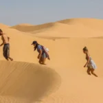 Le Sud tunisien est un monde à part. Dès que l’on quitte la côte, la lumière change, la terre se teinte d’ocre et le silence s’installe. Ici commence un autre voyage : celui des grands espaces, des dunes mouvantes, des villages berbères et des traditions ancestrales. Chez nous, chaque circuit dans le Sud tunisien est pensé comme une immersion totale, un équilibre entre aventure et confort, culture et nature, authenticité et émotion. Que vous partiez de Tunis, Hammamet, Sousse, Djerba ou Tozeur, nos circuits et excursions personnalisées s’adaptent à vos envies – 2 jours, une nuit ou plus, au départ de l’adresse que vous voulez en Tunisie. Découvrez nos suggestions d’itinéraires et préparez votre aventure saharienne sur nos circuits du désert . Découvrir le Sud Tunisien : un patrimoine naturel et humain exceptionnel On parle souvent du Sud tunisien pour ses dunes et son désert. Mais il serait réducteur de le résumer à cela. Ce territoire est d’abord une mosaïque d’ambiances : Le Chott el-Jérid, immense lac salé aux reflets argentés. Les oasis de montagne de Chebika, Tamerza et Mides, où les cascades côtoient les falaises ocres. Les villages troglodytiques de Matmata, creusés dans la roche pour se protéger de la chaleur. Les ksour de Tataouine, véritables châteaux de sable, témoins d’un génie architectural ancestral. Sans oublier le mythique Ksar Ghilane, oasis du bout du monde avec sa source chaude naturelle, ou encore Douz, la "porte du désert", d’où partent les caravanes. Partir en voyage au Sud tunisien, c’est aussi rencontrer un peuple accueillant, fier de son histoire. Les habitants vous inviteront à partager un thé, à goûter un couscous traditionnel ou à écouter un conte transmis de génération en génération. Les circuits les plus demandés : immersion dans le vrai désert Circuit 2 jours / 1 nuit – Première immersion saharienne Un itinéraire court mais complet pour une première expérience du désert. Départ de votre adresse en Tunisie vers Douz, où commence l’aventure. Vous traversez les premières dunes en 4x4, avant de rejoindre votre campement dans le désert. Le soir, dîner sous les étoiles, feu de camp et nuit paisible dans le silence du Sahara. Le lendemain matin, balade à dos de dromadaire ou randonnée sur les crêtes de sable, puis passage par Ksar Ghilane pour un bain dans la source chaude. Un souvenir inoubliable, condensé d’authenticité et de beauté. Circuit 3 jours / 2 nuits – De Douz à Matmata Ce circuit mêle désert, villages berbères et montagne. Jour 1 : départ vers Douz, installation au campement et bivouac saharien. Jour 2 : route vers Ksar Ghilane, bain thermal, visite du fort romain, déjeuner typique puis traversée des plateaux vers Tamezret et Matmata. Jour 3 : découverte des maisons troglodytiques, décor naturel de films mythiques, puis retour à votre point de départ. Circuit 5 jours / 4 nuits – Dunes, oasis et traditions Un itinéraire complet pour les amoureux de la nature et de la culture : Tozeur – Chott el-Jérid – Douz – Ksar Ghilane – Matmata – Tataouine. Entre les palmeraies de Tozeur, les mirages du Chott, les dunes dorées de Douz et les villages fortifiés de Tataouine, ce voyage vous plonge dans un concentré d’émotions. Retrouvez les programmes détaillés sur nos circuits du désert . Les excursions à la journée : condensé d’aventure et de découverte Si vous disposez de peu de temps, nos excursions au départ de Tozeur, Djerba, Douz ou Matmata sont idéales pour explorer sans contrainte. Découvrez par exemple : L’excursion aux oasis de montagne : Chebika, Tamerza et Mides, un trio spectaculaire entre falaises et cascades. L’excursion Douz – Ong Jmel : un aller simple vers les décors de cinéma et les dunes infinies. Matmata & Chenini : immersion dans les villages berbères et leurs traditions ancestrales. Coucher de soleil à Douz : balade à dos de chameau dans une lumière dorée, suivi d’un dîner local. Chaque excursion est accompagnée d’un guide local professionnel, passionné par sa région. Retrouvez l’ensemble de nos offres sur Excursion en Tunisie . Randonnée et trekking : marcher sur les traces des nomades Rien ne permet de ressentir le Sahara comme la marche. Nos randonnées dans le désert tunisien sont organisées en petits groupes, à un rythme doux, entre dunes, oueds et plateaux. Encadrés par des guides chameliers, vous partez à pied ou avec un dromadaire de bât pour 2, 3 ou 5 jours. Les nuits se passent sous la tente, le regard tourné vers la Voie lactée, au cœur d’un silence absolu. Nous proposons aussi des randonnées dans les montagnes du Dahar, entre Chenini et Douiret, ou autour de Tamezret et Matmata. Tous les niveaux sont possibles : du marcheur débutant au randonneur aguerri. Découvrez les itinéraires complets sur Randonnée montagne – Sahara . Dormir sous les étoiles : l’expérience saharienne par excellence Une nuit dans le désert est une expérience qu’on n’oublie pas. Selon votre choix, vous dormirez : en bivouac nomade, simple et magique, autour du feu, en campement confort, avec lit, salle de bain et électricité, ou en maison d’hôtes traditionnelle, au cœur des villages berbères. La cuisine locale est un voyage en soi : couscous parfumé, tajines, briks croustillantes, pain tabouna, dattes fraîches, huile d’olive pure. Nous veillons à respecter vos régimes alimentaires (végétarien, sans gluten ou autre). Services et logistique : tout est pensé pour votre confort Nous prenons en charge depuis l’adresse que vous souhaitez en Tunisie. Vous pouvez arriver par avion à Tunis, Enfidha, Monastir, Djerba ou Tozeur : notre service de navette aéroport s’occupe du transfert. Réservez facilement votre transfert ici : Services navette aéroport . Nos chauffeurs et guides connaissent parfaitement le terrain. Chaque véhicule 4x4 est climatisé, équipé et entretenu pour affronter les pistes du Sud. Nous assurons également un suivi de sécurité, une trousse médicale et une assistance permanente pendant le circuit. Respect, authenticité et engagement local Voyager avec nous, c’est aussi soutenir une économie locale durable : Nous travaillons avec des guides et artisans du Sud tunisien, Les repas sont préparés par des familles locales, Les hébergements valorisent l’architecture traditionnelle, Les déchets sont triés, les sites naturels respectés. Nous croyons à un tourisme humain, intelligent et responsable, loin du tourisme de masse. Préparer son voyage : conseils et essentiels à emporter Tenue : vêtements légers le jour, plus chauds la nuit. Accessoires : chèche, lunettes de soleil, crème solaire, lampe frontale, gourde. Chaussures : confortables, fermées, adaptées à la marche dans le sable. Équipement photo : filtre anti-poussière et batteries de rechange. Santé : hydratation régulière et protection solaire obligatoire. Ces conseils sont développés dans nos articles du blog des excursions en Tunisie . Réserver un circuit personnalisé : simple, rapide et gratuit Vous rêvez d’un voyage dans le désert tunisien ou d’une excursion depuis votre ville ? Remplissez notre formulaire de devis gratuit : indiquez votre adresse de départ, vos dates, la durée souhaitée (2 jours, 3, 5 ou plus) et vos préférences (aventure, culture, détente, confort, famille…). Nous concevons ensuite un itinéraire personnalisé, ajusté à votre rythme et à votre budget. Demandez votre devis gratuit ici . Ce qu’en disent nos voyageurs Nos visiteurs parlent mieux que nous de leur expérience. Lisez leurs avis sur TripAdvisor – Sud Tunisie : ils évoquent la gentillesse des guides, la beauté des paysages, la sensation de liberté et l’organisation irréprochable de nos circuits. Ces retours sont notre plus belle récompense. Pourquoi choisir nos circuits et excursions ? Départ de l’adresse que vous voulez en Tunisie. Circuits personnalisés dès 2 jours/1 nuit jusqu’à 8 jours ou plus. Guides locaux expérimentés et passionnés. Navette aéroport intégrée à la demande. Voyage sur mesure, combinant aventure, détente et culture. Engagement écologique et local. Assistance 24h/24 pendant tout votre séjour. Le Sud Tunisien, un voyage au rythme du sable et du vent Le Sud tunisien ne se raconte pas, il se vit. C’est un espace qui apaise, un lieu où le temps s’étire, où chaque coucher de soleil semble arrêter le monde. Que vous veniez pour deux jours ou pour une semaine, le désert vous laissera une empreinte durable : celle d’un voyage vrai, humain et sensoriel. Le Sahara tunisien n’est pas une destination, c’est une émotion. Et c’est cette émotion que nous vous proposons de vivre, dans les meilleures conditions, au cœur de la Tunisie authentique. 📍 Liens utiles à consulter avant votre départ : Circuits : https://sudtunisie.com/voyage/circuits-desert/ Randonnée : https://sudtunisie.com/voyage/randonnee-montagne-sahara/ Excursions : https://sudtunisie.com/voyage/excursion-en-tunisie/ Blog : https://sudtunisie.com/voyage/blog-excursions-tunisie/ Devis gratuit : https://sudtunisie.com/devis-voyage-desert-sud-tunisie-vacances-pas-cher-tunisie-sahara-tunisie/ Le désert vous attend. Un lever de soleil sur les dunes vaut mille mots. À vous d’écrire le reste du voyage, nous nous chargeons du chemin.