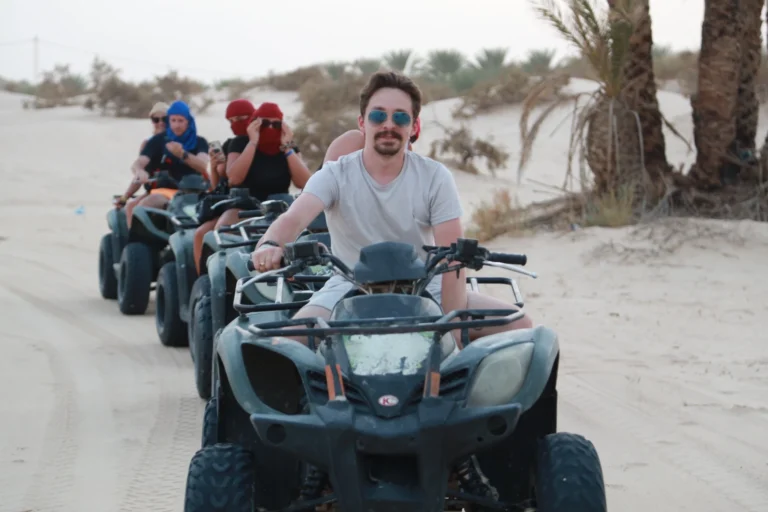 Passer la Fête de fin d’année dans le Sahara tunisien, c’est choisir une expérience inoubliable entre ciel étoilé, dunes dorées et authenticité berbère. Chez sudtunisie.com, nous proposons des circuits privatifs, des excursions sur-mesure et des séjours complets qui transforment le Nouvel An en un moment magique au cœur du désert du sud tunisien. Loin des foules et du froid hivernal, vivez une aventure chaleureuse, humaine et dépaysante. Pourquoi fêter le Nouvel An dans le Sahara tunisien ? Imaginez un réveillon sous les étoiles, entouré de dunes et du silence absolu du désert. Finir l’année au Sahara, c’est dire adieu à la routine pour plonger dans une parenthèse d’évasion et de sérénité. Les températures douces, le ciel limpide et la convivialité tunisienne font de cette saison la meilleure période pour voyager. Nous créons pour vous des circuits personnalisés où chaque détail est pensé : hébergements de charme, transferts privés, repas typiques, et une ambiance authentique autour du feu pour accueillir la nouvelle année. Consultez nos suggestions de circuits désert pour trouver le voyage qui vous ressemble. Nos circuits de fin d’année : entre magie et découverte Chaque circuit que nous proposons s’adapte à vos envies : aventure, confort, culture ou détente. Voici les étapes phares de nos circuits Sahara pour le Nouvel An : 1. Djerba ou Tozeur – porte d’entrée du désert Arrivée à Djerba ou Tozeur, où notre navette aéroport vous accueille avec le sourire. Dès les premiers instants, vous ressentez la chaleur humaine du Sud. Installation dans votre hôtel ou maison d’hôtes et briefing personnalisé avant de prendre la route vers le désert. 2. Les oasis de montagne : Chebika, Tamerza, Mides Ces joyaux naturels perchés dans les montagnes offrent une vue spectaculaire sur les vallées verdoyantes. Chebika la lumineuse, Tamerza la verdoyante et Mides la vertigineuse séduisent les amateurs de randonnées et de photographie. Pour une expérience active, découvrez nos randonnées montagne & Sahara accompagnées par des guides passionnés. 3. Le Chott El Jerid – le lac de sel aux reflets infinis Ce lac mythique, célèbre pour ses mirages et ses couleurs changeantes, est un incontournable. À l’aube, les teintes rosées du Chott El Jerid offrent un spectacle magique. C’est ici que le Sahara commence à se dévoiler. 4. Douz et les dunes infinies Douz, surnommée la “porte du désert”, marque le départ vers les grands ergs. C’est l’occasion de monter sur un dromadaire et de glisser doucement entre les vagues de sable doré. Une expérience simple, apaisante et intemporelle. 5. Ksar Ghilane – oasis et source chaude Nichée au milieu des dunes, Ksar Ghilane est une oasis légendaire. Vous pourrez y baigner dans la source chaude, explorer les alentours en quad ou simplement vous détendre au campement. Les couchers de soleil y sont inoubliables. 6. Nuit du réveillon au campement C’est le point d’orgue du voyage : un dîner saharien sous les étoiles, musique traditionnelle, feu de camp, et la magie du désert pour célébrer la nouvelle année. Nos campements confortables offrent tentes privatives, literie de qualité et ambiance conviviale. Pour une version plus exclusive, nous proposons des bivouacs privés en plein désert. Expérience authentique : gastronomie, culture et rencontres Le charme d’un circuit dans le sud tunisien, c’est aussi la rencontre avec les habitants. Vous dégusterez des plats traditionnels comme le couscous du Sud, le pain cuit sous le sable, ou les fameuses dattes Deglet Nour. Chaque étape est une immersion culturelle : potiers de Guellala, tisserandes de Chenini, guides du désert ou cuisinières des oasis. Ces moments simples et sincères donnent tout son sens à l’expression “voyager autrement”. Hébergements & confort : entre charme et nature Nous sélectionnons avec soin des hébergements adaptés à votre style de voyage : Maisons d’hôtes de charme dans les oasis pour un contact direct avec la population locale. Campements sahariens pour une immersion totale dans le désert. Hôtels confortables à Djerba, Tozeur ou Douz pour se détendre après la route. Chaque hébergement est testé et validé pour garantir propreté, sécurité et authenticité. Découvrez toutes nos formules sur sudtunisie.com . Une aventure personnalisée selon vos envies Nous croyons qu’aucun voyage ne devrait être identique. Nos circuits de fin d’année au Sahara tunisien s’adaptent à tous : Couples cherchant un réveillon romantique sous les étoiles. Familles voulant partager un moment unique ensemble. Groupes d’amis désireux d’une expérience hors du commun. Voyageurs solo en quête de silence et de beauté. Vous décidez du rythme, du niveau de confort, du type d’hébergement et des activités. Pour un programme sur mesure, remplissez notre formulaire de devis gratuit . Activités à ne pas manquer pendant la fête de fin d’année Balade à dos de dromadaire au coucher du soleil Randonnée dans les oasis de montagne Visite des villages troglodytiques de Matmata et Chenini Excursion vers les ksour de Tataouine Nuit en campement avec musique et dîner saharien Observation des étoiles dans le silence absolu du désert Ces expériences sont au cœur de notre passion pour le voyage dans le sud tunisien. Retrouvez-les sur notre page dédiée aux excursions en Tunisie . Conseils pratiques pour bien préparer votre voyage Meilleure période : de décembre à mars, avec des journées douces et des soirées fraîches. Tenue : vêtements légers pour la journée, veste chaude pour le soir, chapeau et lunettes de soleil. Transport : nous assurons tous les transferts avec notre service navette aéroport . Santé : prévoyez une petite trousse de secours et une crème hydratante. Photographie : le lever et le coucher du soleil sont des moments magiques à ne pas manquer. Votre sécurité et votre confort avant tout Nos guides et chauffeurs professionnels assurent votre sécurité à chaque étape. Chaque circuit est planifié avec soin : itinéraires testés, matériel de secours, communication satellite dans le désert, et suivi 24h/24 par notre équipe logistique. Votre tranquillité d’esprit est notre priorité, pour que vous puissiez simplement profiter de chaque instant. Avis et témoignages de voyageurs La satisfaction de nos voyageurs est notre meilleure récompense. Découvrez les avis sur Tripadvisor , où Sud Tunisie est salué pour la qualité de ses circuits, la gentillesse de ses guides et la magie des moments vécus. Chaque commentaire reflète notre passion : faire de chaque séjour une aventure mémorable et sincère. Réserver votre circuit de fin d’année dans le Sahara tunisien Rien de plus simple : Consultez nos circuits désert . Choisissez vos dates et vos envies. Recevez un devis gratuit et personnalisé . Profitez d’un service complet, incluant transfert, hébergement, activités et repas. Pour compléter votre expérience, explorez aussi : Randonnée montagne & Sahara Excursions en Tunisie Blog – Excursions Tunisie Un réveillon sous les étoiles : une expérience à vivre au moins une fois Fêter le Nouvel An dans le désert tunisien, c’est ralentir le temps, ressentir l’immensité et redécouvrir la beauté du silence. C’est aussi partager un moment rare, au coin du feu, entouré de visages souriants et d’une nature infinie. Avec Sud Tunisie, chaque voyage est une promesse : celle d’un Sahara vivant, poétique et accueillant, où chaque lever de soleil marque un nouveau départ. Réservez dès maintenant votre circuit de fin d’année et laissez la magie du Sahara tunisien illuminer vos fêtes.