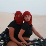 Passer la fin d’année au Sahara tunisien, c’est s’offrir une parenthèse lumineuse entre dunes dorées, oasis vivantes et ciels constellés. Nous créons des circuits privatifs et des excursions sur-mesure pour Noël et le Nouvel An : itinéraires flexibles, hôtels et campements de caractère, guides locaux passionnés, logistique fluide dès votre arrivée. Que vous rêviez d’un réveillon sous les étoiles, d’une immersion douce en famille ou d’un road trip avisé entre Tozeur, Douz, Matmata, Chenini et Ksar Ghilane, nous réglons chaque détail pour que votre séjour soit simple à vivre et inoubliable. Pour explorer nos idées d’itinéraires, parcourez nos circuits désert . Pourquoi le Sahara tunisien est idéal pour Noël & Nouvel An ? La saison de fin d’année en Tunisie conjugue météo douce, fréquentation raisonnable et lumières spectaculaires sur les reliefs. En choisissant un circuit en privé, vous profitez : d’un rythme à votre mesure : départs tôt pour les plus belles lumières, siestes ou pauses gourmandes quand vous voulez ; de trajets optimisés entre sites majeurs (Chebika, Tamerza, Mides, Chott El Jerid, Douz, Ksar Ghilane, Matmata, Chenini) pour éviter les foules ; d’hébergements vérifiés (maisons d’hôtes, lodges, campements confort) adaptés à votre budget ; d’une logistique clé en main, incluant la navette aéroport (Tozeur, Djerba ou Tunis selon vos vols) ; d’expériences authentiques : pain cuit sous le sable, thé à la menthe, ateliers d’artisanat, rencontres avec les habitants des oasis. Nous pensons le voyage comme une suite de moments forts : coucher de soleil sur une crête de dunes, bivouac confortable au milieu de nulle part, matinées dorées dans les gorges de montagne, banquet saharien pour le réveillon. Nos circuits désert de fin d’année : privatisés & 100% personnalisables Chaque voyage est construit sur-mesure : durée, confort, activités, équilibre “route / détente”. Pour vous projeter dès maintenant, découvrez la collection circuits désert ; nous y adaptons l’ambiance “fêtes de fin d’année” (menus de réveillon, moments signature, petites attentions en chambre). En complément, nos excursions en Tunisie permettent d’ajouter une journée thématique (oasis, dunes, villages troglodytiques, artisanat) à un séjour plus court. Programme type “Noël & Nouvel An au Sahara” – 6 à 8 jours en privé Un canevas efficace, modulable en 6, 7 ou 8 jours, qui couvre les incontournables sans courir. Nous personnalisons ensuite chaque journée selon vos envies (famille, couple, amis, photographie, randonnée, bien-être). Jour 1 – Arrivée & première immersion Accueil par notre équipe et transfert privé via la navette aéroport jusqu’à votre maison d’hôtes. Balade tranquille dans l’oasis ; briefing personnalisé : météo, choix des spots “golden hour”, options réveillon, souhaits culinaires. Dîner local et nuit sereine. Jour 2 – Chebika, Tamerza, Mides : les oasis de montagne Montée progressive vers les terrasses verdoyantes et canyons sculptés. Chebika pour les palmeraies, Tamerza pour ses panoramas, Mides pour sa gorge spectaculaire. Nous ajustons le timing pour éviter les heures d’affluence et profiter d’une lumière rasante parfaite. Possibilité d’une mini-randonnée (facile à modérée) à piocher dans Randonnée montagne & Sahara . Jour 3 – Chott El Jerid & Douz : portes du Sahara Au matin, traversée du Chott El Jerid, lac salé aux miroirs de lumière. Arrêts photos sur les lignes de sel, route vers Douz. Balade à dromadaire au crépuscule (en option), initiation au pain de sable, dégustations de produits dattiers. Selon vos envies, première nuit en campement : tentes privées, literie douillette, dîner sous les lanternes. Jour 4 – Mer de dunes & bivouac confort Journée hors-piste entre ergs et regs. Déjeuner en mode pique-nique gourmand, haltes “photo-spotting” sur des arêtes de dunes. Installation au camp saharien (sanitaires partagés ou privatifs selon la catégorie). Observation des étoiles après dîner : le silence, le ciel profond, le temps suspendu. Jour 5 – Ksar Ghilane & source chaude Route vers Ksar Ghilane, oasis ourlée de dunes, bain en source chaude (selon la météo), farniente sous les palmes. Boucle 4×4 possible vers un vieux fortin pour des vues à 360°. Cap ensuite sur Matmata (maisons troglodytiques) pour une rencontre avec des familles gardiennes d’un art de vivre millénaire. Jour 6 – Matmata troglodytique & Chenini (Tataouine) Visite immersive des habitations troglodytiques de Matmata (architecture vernaculaire, ingénierie climatique naturelle), puis route vers Chenini et ses ksour (greniers collectifs). Pause tisanes, atelier d’artisanat (poterie, tissage). Nuit en maison d’hôtes de charme ou retour vers Djerba. Jour 7 – Djerba & Guellala, Houmt Souk Flânerie à Guellala, village de potiers, puis Houmt Souk : ruelles, échoppes, déjeuner de poissons. Nous profitons de cette journée pour peaufiner votre soirée du 31 décembre ou du 24 décembre (selon vos dates) : table en bord de mer, ambiance musicale en ville ou retour au désert si vous préférez un réveillon intime. Jour 8 – Départ en douceur Derniers achats, plage ou dernière mini-excursion. Transfert retour soigné. Vous repartez avec notre carnet de souvenirs et vos plus belles photos. Pour varier les plaisirs, nous alternons routes scéniques, temps de repos, séances photo au lever/coucher, balades tranquilles choisies sur Randonnée montagne & Sahara , et moments conviviaux avec les habitants. Réveillon saharien : dîner sous les étoiles & ambiance chaleureuse Nous organisons sur demande un réveillon inoubliable en campement : Dîner saharien (chorba parfumée, couscous, méchoui, pain de sable, dattes Deglet Nour, douceurs) ; Musique traditionnelle ou veillée contée autour du feu (selon disponibilité et souhaits) ; Mise en scène sobriété élégante : lanternes, ciel étoilé, silence préservé ; Retrait des déchets et respect des lieux (pas de feux d’artifice dans les dunes, pour des raisons de sécurité et d’écosystème). Pour un réveillon urbain, nous suggérons des adresses chaleureuses à Djerba, Tozeur ou Tataouine, tout en privatisant les transferts grâce à la navette aéroport et à nos chauffeurs 4×4. Hébergements & campements : confort, cachet & emplacement idéal Nous sélectionnons des adresses testées : Maisons d’hôtes de charme (hospitalité, cuisine familiale, calme) ; Lodges & hôtels 3★ à 5★ selon votre standard ; Campements sahariens avec tentes privées, sanitaires soignés, douches chaudes ; Bivouacs exclusifs (sur demande) : isolation totale, équipe dédiée, protocole de sécurité. Chaque choix répond à des critères précis : propreté, literie, silence nocturne, proximité des sites pour maximiser vos heures dorées. Comparez, puis concevez votre mix idéal à partir des circuits désert . Expériences & activités à ajouter Balade à dromadaire au crépuscule : icône du Sahara, parfaite pour les familles ; Boucles 4×4 “photo-spotting” : repérage des courbes de dunes les plus graphiques ; Randonnées facile à modérées dans les oasis de montagne et sur l’erg : idées sur Randonnée montagne & Sahara ; Ateliers & rencontres : poterie à Guellala, tissage, herboristerie ; Parenthèses bien-être : bain de source chaude à Ksar Ghilane (selon la météo) ; Excursions ciblées à greffer via Excursion en Tunisie ; Inspiration & récits : blog des excursions en Tunisie . Conseils pratiques de fin d’année : météo, équipement, rythme Températures : journées douces, soirées fraîches ; emportez couches superposables, coupe-vent, chèche ou casquette. Soleil & confort : lunettes, crème solaire, baume à lèvres ; gourde réutilisable pour limiter les plastiques. Chaussures : baskets ou chaussures de marche légères (sable + sentiers). Photo : filtres UV, chiffon anti-poussière, batteries externes. Santé : petite trousse (pansements, antiseptique, antalgiques) ; assurance voyage à jour. Réservations : sur la période Noël / Nouvel An, anticipez pour sécuriser les coup de cœur (campements, chambres de charme, musiciens). Transferts & logistique : simplicité totale dès l’atterrissage Nous coordonnons vos vols et mettons en place la navette aéroport à Tozeur, Djerba ou Tunis : Accueil personnalisé, chauffeur ponctuel, eau à bord, sièges enfants si besoin ; Transferts privés entre aéroports, hôtels, oasis, campements ; Horaires ajustés pour ne rien manquer des heures dorées et revenir sereins après le réveillon. Tarifs, disponibilités & devis express Le prix dépend de la durée, du niveau d’hébergement, du nombre de voyageurs et des activités. Obtenez une estimation claire en 2 minutes via notre devis gratuit et sans engagement . Nous détaillons inclus / non inclus et proposons des options (réveillon saharien, musiciens, ateliers, extensions balnéaires ou culturelles). Avis & confiance : ce que disent nos voyageurs La satisfaction de nos hôtes guide nos choix. Lisez des retours transparents et des expériences vécues sur Tripadvisor : Sud Tunisie – Tozeur . Ces témoignages reflètent notre exigence de qualité et notre sens du détail. FAQ – Fin d’année au Sahara en privé Combien de jours pour un beau panorama du Sud tunisien ? Nous recommandons 6 à 8 jours pour combiner oasis, dunes, villages, avec un rythme confortable. 4–5 jours restent possibles pour une mise en bouche. Réveillon dans le désert ou en ville ? Les deux ! Réveillon saharien (campement, dîner sous les étoiles, veillée musicale) pour la magie ; réveillon urbain (Djerba, Tozeur) pour l’animation. Nous réservons et organisons vos transferts. Fin d’année adaptée aux enfants ? Oui. Étapes courtes, temps calmes en milieu d’après-midi, activités ludiques (dromadaire, pain de sable). Nos guides s’ajustent au rythme familial. Peut-on ajouter de la marche ? Bien sûr : boucles faciles dans les oasis et sur les bords d’erg, tirées de Randonnée montagne & Sahara . Faut-il craindre le froid la nuit ? Les campements fournissent couvertures et literie adaptées ; nous suggérons une couche thermique légère pour un confort optimal. Comment réserver simplement ? Parcourez nos circuits désert , puis demandez votre devis gratuit personnalisé . Nous ajustons, vous validez. Itinéraires associés & extensions “début d’année” Grand tour des oasis & ksour : Chebika, Tamerza, Mides, Matmata, Chenini, Douiret, Ksar Ghilane – base circuits désert . Version “nature active” : plus de pas, plus de points de vue ; piochez des idées sur Randonnée montagne & Sahara . Focus artisanat & saveurs : ajoutez des excursions en Tunisie et suivez les tendances sur le blog . Séjour mixte désert & mer : terminez à Djerba pour un début d’année tout en douceur. Prêts pour un Noël ou un Nouvel An magistral sous les étoiles du Sahara ? Transformez votre fin d’année en souvenir magistral : une nuit de réveillon au milieu des dunes, un lever de soleil sur le Chott, la chaleur des oasis en hiver. Commencez par explorer nos circuits désert , puis demandez votre devis gratuit détaillé . Pour enrichir l’aventure, ajoutez une randonnée montagne & Sahara , pimentez d’une excursion ciblée et glanez des idées fraîches sur le blog des excursions en Tunisie . Nous préparons, vous savourez. Joyeuses fêtes au Sahara !