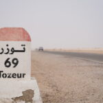 Plonger dans le Sahara du Sud tunisien n’est pas un simple voyage, c’est une rencontre avec l’essentiel : la lumière des dunes, le silence riche de sens, la générosité des oasis, l’hospitalité bédouine et ces nuits d’étoiles qui semblent à portée de main. Nous concevons des circuits et excursions sur mesure qui relient les grands classiques (Tozeur, Douz, Ksar Ghilane, Matmata, Chenini, Tataouine…) aux pépites secrètes, avec un seul fil conducteur : l’authenticité, la sécurité et le confort. Dès maintenant, explorez nos programmes ici : Circuits désert Tunisie . Pourquoi choisir SudTunisie.com pour votre circuit dans le Sud tunisien ? Nous sommes des passionnés du désert. Notre équipe locale vit le Sud au quotidien, connaît les pistes, les microclimats, les campements de charme et les artisans qui font battre le cœur de la région. Nous proposons : Des itinéraires 100 % personnalisables (familles, couples, groupes d’amis, incentives). Des guides francophones et expérimentés, formés à l’orientation et à la sécurité en milieu saharien. Des véhicules 4×4 récents et climatisés, conduits par des chauffeurs chevronnés. Des hébergements à la carte : tentes bédouines, campements de charme, maisons d’hôtes, hôtels oasis. Une logistique fluide : transferts, horaires adaptés, assistance 24/7, prise en charge dès l’aéroport si besoin via notre service de navette aéroport . Nos circuits sont disponibles au départ de Tunis, Hammamet, Sousse, Monastir, Sfax, Djerba, Gabès, Bizerte, Kélibia et Korba, avec un timing optimisé pour profiter des plus belles lumières du désert. Grand Tour d’horizons : les lieux emblématiques du Sahara Sud Tozeur, porte des oasis et décors de cinéma Tozeur charme par sa palmeraie, ses ruelles aux briques ocre et ses portes sculptées. À proximité, les oasis de montagne – Chebika, Tamerza, Mides – dévoilent canyons, cascades et panoramas spectaculaires. Au lever du soleil, les contrastes sont époustouflants ; au coucher, les reliefs se parent d’or. Pour combiner marche douce, points de vue et fraîcheur des sources, optez pour notre randonnée montagne Sahara . Chott El-Jérid, le lac de sel aux mirages Immensité laiteuse l’hiver, miroir géant au printemps, le Chott El-Jérid offre une traversée hypnotique. On y saisit l’échelle du désert, son silence vibrant, ses mirages changeants. Une pause photo au bon spot transforme le souvenir en carte postale intemporelle. Douz, la mer de dunes et la culture nomade Surnommée la « porte du désert », Douz se vit en 4×4, à pied ou à dos de dromadaire. L’expérience phare : le coucher du soleil sur les dunes, suivi d’un dîner sous tente, pain de sable et thé à la menthe. Ici, le temps ralentit, la conversation s’allume ; on écoute les histoires de piste, on apprend les gestes simples qui font la vie au désert. Ksar Ghilane, l’oasis du bout du monde Écrin de palmiers et source chaude naturelle, Ksar Ghilane est un paradis pour bain thermal en plein désert, balade à quad (optionnelle) vers un petit fort romain, et surtout bivouac sous un firmament éblouissant. C’est l’étape que beaucoup qualifient de “révélation”. Matmata, troglodytes et ambiance lunaire Avec ses habitations creusées dans la roche, Matmata semble sortie d’un autre monde. La fraîcheur des maisons, l’ingéniosité de l’architecture, les paysages ondulés… Tout y raconte l’adaptation au climat. C’est aussi un décor mythique, souvent lié à l’imaginaire cinématographique. Tataouine, Chenini et les ksour du Sud Le pays berbère aligne villages perchés (Chenini, Douiret) et ksour (greniers fortifiés). Les vues panoramiques sont somptueuses, l’histoire est palpable, l’accueil sincère. On y comprend la logique des anciennes routes caravanières et la poésie d’une vie accrochée aux reliefs. Pour une première inspiration détaillée, feuilletez notre sélection d’excursions en Tunisie et nos circuits désert . Nos types de circuits : liberté, immersion et rythme juste Circuits courts (1 à 2 jours) Parfaits si vous séjournez sur la côte ou à Tunis et souhaitez “toucher” le Sahara sans tout réorganiser. Exemple : 1 jour : départ matinal, Douz via le Chott El-Jérid, balade dans les dunes, déjeuner typique, retour en soirée. 2 jours : Tozeur – Chebika – Tamerza – Mides (jour 1), Chott – Douz – coucher de soleil – bivouac (jour 2). Ces formats sont très prisés depuis Hammamet, Sousse, Monastir, Sfax ou Djerba. Contactez-nous pour un devis gratuit et un timing calé à vos vols. Circuits signatures (3 à 5 jours) Le meilleur équilibre entre diversité des paysages et rythme confortable. Exemple “grands essentiels” : Jour 1 : arrivée Tozeur, oasis de montagne (Chebika, Tamerza, Mides). Jour 2 : Chott El-Jérid, Douz (dromadaire au coucher de soleil). Jour 3 : Ksar Ghilane (bain dans la source chaude, bivouac sous les étoiles). Jour 4 : Matmata, traversée vers Tataouine – Chenini. Jour 5 : Découverte des ksour, déjeuner terroir, retour Djerba ou aéroport. Chaque journée est modulable (durée de marche, options en 4×4, visites artisanales), avec des pauses photo soigneusement repérées. Circuits aventure 4×4 et trekking Vous aimez la piste, les ergs et le goût discret de l’adrénaline ? Nous traçons des itinéraires sur des secteurs peu fréquentés, toujours en sécurité, avec l’appui d’équipes locales. Côté marche, notre randonnée montagne Sahara offre de sublimes contrastes : gorges, plateaux, oasis suspendues, villages d’argile. Circuits famille et slow travel Rythmes doux, hébergements confortables, petites marches ludiques, ateliers (pain de sable, observation des étoiles, contes bédouins) : l’idéal pour voyager avec enfants et créer des souvenirs qui comptent. Nous adaptons les distances, les horaires, les repas ; vous profitez, on gère ! Départs et logistique : on s’occupe de tout Nous assurons des départs garantis et des transferts fluides depuis Tunis, Hammamet, Sousse, Monastir, Sfax, Djerba, Gabès, Bizerte, Kélibia et Korba. Selon votre lieu d’arrivée ou de séjour : Navette aéroport à l’arrivée / au départ via notre service dédié : transferts et navettes . Horaires optimisés pour profiter des plus belles lumières et éviter les pics de chaleur. Assistance 24/7 : un imprévu ? Nous réajustons en douceur. Options confort : chambre avec vue oasis, campement premium, massages traditionnels, dîner privé sous les étoiles. L’esprit SudTunisie.com : authenticité, respect et sécurité Notre promesse : voyager juste. Cela signifie : Respect des communautés : rémunération équitable des guides, chauffeurs, cuisiniers, chameliers. Impact maîtrisé : gestion des déchets, usage raisonné de l’eau, itinéraires qui préservent les milieux. Sécurité : briefings clairs, choix d’itinéraires adaptés aux conditions, matériel vérifié, protocole météo. Cuisine locale : couscous au feu de bois, tajines, dattes de Tozeur, pain de sable ; options végétariennes/vegan sur demande. Envie de retours concrets ? Lisez les avis de nos voyageurs : Sud Tunisie sur TripAdvisor . Trois idées d’itinéraires pour rêver (et réserver) Échappée 2 jours – Dunes et oasis Jour 1 : Départ (Tunis/Hammamet/Sousse/Monastir/Sfax/Djerba/Gabès/Bizerte/Kélibia/Korba). Traversée du Chott El-Jérid, arrivée Douz, balade à dos de dromadaire au coucher de soleil, dîner traditionnel, nuit en campement. Jour 2 : Pistes légères au petit matin, visite artisanat local, déjeuner terroir, retour vers votre ville de départ. 👉 Programme modulable : Excursion en Tunisie . Immersion 4 jours – Oasis, dunes, troglodytes Jour 1 : Tozeur, oasis de montagne (Chebika, Tamerza), canyon de Mides. Jour 2 : Chott – Douz, dromadaire, soirée sous la tente, contes et étoilements. Jour 3 : Ksar Ghilane, bain dans la source chaude, pistes vers l’erg, bivouac premium. Jour 4 : Matmata, maisons troglodytes, panoramas lunaires, retour (Djerba/Tunis/etc.). 👉 Inspirations et variantes : Circuits désert . Grande Traversée 6 jours – Sahara & pays berbère Jour 1 : Djerba – Tataouine, ksour et dunes rouges. Jour 2 : Chenini et villages perchés, dîner terroir. Jour 3 : Cap sur Ksar Ghilane, source, bivouac. Jour 4 : Douz, balade saharienne, campement de charme. Jour 5 : Chott El-Jérid – Tozeur, flânerie palmeraie. Jour 6 : Chebika – Tamerza – Mides, retour par navette. 👉 Personnalisez selon vos dates : Devis gratuit / contact . Quand partir, que prévoir ? Nos conseils d’experts Saisons : le printemps et l’automne offrent des températures idéales ; l’hiver est lumineux (nuits fraîches, belles lumières) ; l’été se vit tôt le matin et en fin d’après-midi, avec des pauses ombragées. Tenues : vêtements légers à manches longues, foulard/chèche, lunettes et crème solaire, veste chaude pour la nuit. Santé & confort : hydratation régulière, chaussures fermées, protection du sable (housse, zip-bags), trousse minimaliste. Photo : les golden hours valent de l’or ; prévoyez batterie/powerbank et chiffons doux pour l’objectif. Réservation simple, accompagnement soigné Exploration : feuilletez nos circuits désert , nos excursions en Tunisie et nos idées randonnée montagne Sahara . Devis rapide : partagez vos dates, votre ville de départ (Tunis, Hammamet, Sousse, Monastir, Sfax, Djerba, Gabès, Bizerte, Kélibia, Korba), votre style d’hébergements et votre rythme : devis gratuit / contact . Confirmation : on verrouille les étapes, on ajuste les options (bivouac premium, quad à Ksar Ghilane, veillée contes, ateliers). Logistique : transferts navette aéroport , brief personnalisé, assistance 24/7. C’est parti : cap sur les dunes ! Pour prolonger l’inspiration et glaner de bons plans, consultez notre blog d’excursions en Tunisie . FAQ express – Ce que vous nous demandez le plus souvent Combien de temps faut-il pour “bien voir” le Sud ? En 3 à 4 jours, vous reliez élégamment oasis, dunes et troglodytes. En 5 à 6 jours, vous signez une grande traversée, plus lente et mémorable. Peut-on voyager avec de jeunes enfants ? Oui. Nous adaptons distances, horaires, menus, pauses et activités (petites marches, ateliers ludiques) pour que parents et enfants profitent vraiment. Faut-il un équipement spécifique ? Rien de technique : vêtements couvrants mais respirants, bonne hydratation, protection solaire. Nous fournissons le matériel bivouac si option choisie. Les repas sont-ils adaptés aux régimes particuliers ? Bien sûr : végétarien/vegan, sans gluten, allergies spécifiques. Signalez-les au moment du devis . Peut-on arriver par Tunis, Djerba, Sfax… ? Oui : départs et retours depuis Tunis, Hammamet, Sousse, Monastir, Sfax, Djerba, Gabès, Bizerte, Kélibia et Korba. Nous gérons les transferts avec notre navette aéroport . Quels sont vos avis clients ? Ils sont publics et régulièrement mis à jour : Sud Tunisie – TripAdvisor . Prêts pour l’aventure ? Le Sahara vous attend Que vous rêviez d’une échappée de 2 jours, d’un grand circuit de 5 à 6 jours, d’une randonnée en montagne saharienne ou d’un bivouac sous un ciel d’étoiles, nous bâtissons l’itinéraire qui vous ressemble. Le Sud tunisien n’est pas seulement une destination ; c’est une émotion durable, un retour à l’essentiel, un voyage qui se raconte encore longtemps après. Explorez nos circuits désert Inspirez-vous avec nos excursions en Tunisie Osez la randonnée montagne Sahara Lisez, rêvez, préparez sur le blog – excursions Tunisie Organisez vos transferts en navette aéroport Demandez votre devis gratuit / contact Consultez nos avis TripAdvisor Le désert est une promesse : celle d’un temps suspendu, d’une lumière pure et d’une hospitalité vraie. Avec SudTunisie.com, transformez cette promesse en souvenirs inoubliables.