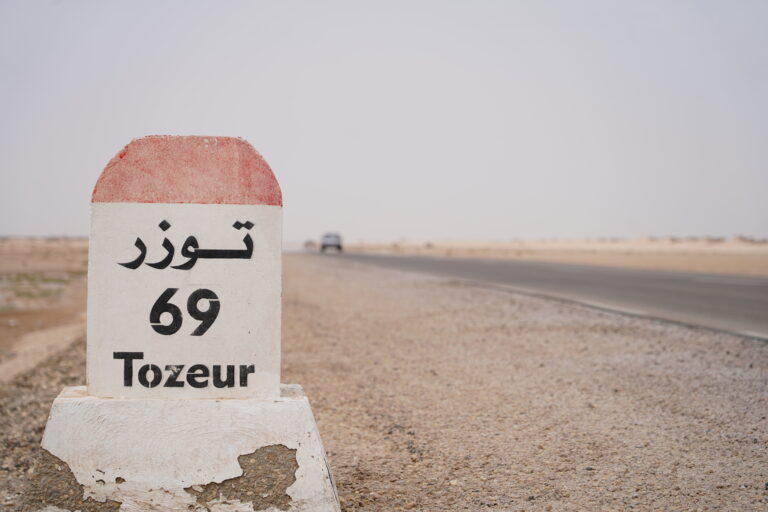 Plonger dans le Sahara du Sud tunisien n’est pas un simple voyage, c’est une rencontre avec l’essentiel : la lumière des dunes, le silence riche de sens, la générosité des oasis, l’hospitalité bédouine et ces nuits d’étoiles qui semblent à portée de main. Nous concevons des circuits et excursions sur mesure qui relient les grands classiques (Tozeur, Douz, Ksar Ghilane, Matmata, Chenini, Tataouine…) aux pépites secrètes, avec un seul fil conducteur : l’authenticité, la sécurité et le confort. Dès maintenant, explorez nos programmes ici : Circuits désert Tunisie . Pourquoi choisir SudTunisie.com pour votre circuit dans le Sud tunisien ? Nous sommes des passionnés du désert. Notre équipe locale vit le Sud au quotidien, connaît les pistes, les microclimats, les campements de charme et les artisans qui font battre le cœur de la région. Nous proposons : Des itinéraires 100 % personnalisables (familles, couples, groupes d’amis, incentives). Des guides francophones et expérimentés, formés à l’orientation et à la sécurité en milieu saharien. Des véhicules 4×4 récents et climatisés, conduits par des chauffeurs chevronnés. Des hébergements à la carte : tentes bédouines, campements de charme, maisons d’hôtes, hôtels oasis. Une logistique fluide : transferts, horaires adaptés, assistance 24/7, prise en charge dès l’aéroport si besoin via notre service de navette aéroport . Nos circuits sont disponibles au départ de Tunis, Hammamet, Sousse, Monastir, Sfax, Djerba, Gabès, Bizerte, Kélibia et Korba, avec un timing optimisé pour profiter des plus belles lumières du désert. Grand Tour d’horizons : les lieux emblématiques du Sahara Sud Tozeur, porte des oasis et décors de cinéma Tozeur charme par sa palmeraie, ses ruelles aux briques ocre et ses portes sculptées. À proximité, les oasis de montagne – Chebika, Tamerza, Mides – dévoilent canyons, cascades et panoramas spectaculaires. Au lever du soleil, les contrastes sont époustouflants ; au coucher, les reliefs se parent d’or. Pour combiner marche douce, points de vue et fraîcheur des sources, optez pour notre randonnée montagne Sahara . Chott El-Jérid, le lac de sel aux mirages Immensité laiteuse l’hiver, miroir géant au printemps, le Chott El-Jérid offre une traversée hypnotique. On y saisit l’échelle du désert, son silence vibrant, ses mirages changeants. Une pause photo au bon spot transforme le souvenir en carte postale intemporelle. Douz, la mer de dunes et la culture nomade Surnommée la « porte du désert », Douz se vit en 4×4, à pied ou à dos de dromadaire. L’expérience phare : le coucher du soleil sur les dunes, suivi d’un dîner sous tente, pain de sable et thé à la menthe. Ici, le temps ralentit, la conversation s’allume ; on écoute les histoires de piste, on apprend les gestes simples qui font la vie au désert. Ksar Ghilane, l’oasis du bout du monde Écrin de palmiers et source chaude naturelle, Ksar Ghilane est un paradis pour bain thermal en plein désert, balade à quad (optionnelle) vers un petit fort romain, et surtout bivouac sous un firmament éblouissant. C’est l’étape que beaucoup qualifient de “révélation”. Matmata, troglodytes et ambiance lunaire Avec ses habitations creusées dans la roche, Matmata semble sortie d’un autre monde. La fraîcheur des maisons, l’ingéniosité de l’architecture, les paysages ondulés… Tout y raconte l’adaptation au climat. C’est aussi un décor mythique, souvent lié à l’imaginaire cinématographique. Tataouine, Chenini et les ksour du Sud Le pays berbère aligne villages perchés (Chenini, Douiret) et ksour (greniers fortifiés). Les vues panoramiques sont somptueuses, l’histoire est palpable, l’accueil sincère. On y comprend la logique des anciennes routes caravanières et la poésie d’une vie accrochée aux reliefs. Pour une première inspiration détaillée, feuilletez notre sélection d’excursions en Tunisie et nos circuits désert . Nos types de circuits : liberté, immersion et rythme juste Circuits courts (1 à 2 jours) Parfaits si vous séjournez sur la côte ou à Tunis et souhaitez “toucher” le Sahara sans tout réorganiser. Exemple : 1 jour : départ matinal, Douz via le Chott El-Jérid, balade dans les dunes, déjeuner typique, retour en soirée. 2 jours : Tozeur – Chebika – Tamerza – Mides (jour 1), Chott – Douz – coucher de soleil – bivouac (jour 2). Ces formats sont très prisés depuis Hammamet, Sousse, Monastir, Sfax ou Djerba. Contactez-nous pour un devis gratuit et un timing calé à vos vols. Circuits signatures (3 à 5 jours) Le meilleur équilibre entre diversité des paysages et rythme confortable. Exemple “grands essentiels” : Jour 1 : arrivée Tozeur, oasis de montagne (Chebika, Tamerza, Mides). Jour 2 : Chott El-Jérid, Douz (dromadaire au coucher de soleil). Jour 3 : Ksar Ghilane (bain dans la source chaude, bivouac sous les étoiles). Jour 4 : Matmata, traversée vers Tataouine – Chenini. Jour 5 : Découverte des ksour, déjeuner terroir, retour Djerba ou aéroport. Chaque journée est modulable (durée de marche, options en 4×4, visites artisanales), avec des pauses photo soigneusement repérées. Circuits aventure 4×4 et trekking Vous aimez la piste, les ergs et le goût discret de l’adrénaline ? Nous traçons des itinéraires sur des secteurs peu fréquentés, toujours en sécurité, avec l’appui d’équipes locales. Côté marche, notre randonnée montagne Sahara offre de sublimes contrastes : gorges, plateaux, oasis suspendues, villages d’argile. Circuits famille et slow travel Rythmes doux, hébergements confortables, petites marches ludiques, ateliers (pain de sable, observation des étoiles, contes bédouins) : l’idéal pour voyager avec enfants et créer des souvenirs qui comptent. Nous adaptons les distances, les horaires, les repas ; vous profitez, on gère ! Départs et logistique : on s’occupe de tout Nous assurons des départs garantis et des transferts fluides depuis Tunis, Hammamet, Sousse, Monastir, Sfax, Djerba, Gabès, Bizerte, Kélibia et Korba. Selon votre lieu d’arrivée ou de séjour : Navette aéroport à l’arrivée / au départ via notre service dédié : transferts et navettes . Horaires optimisés pour profiter des plus belles lumières et éviter les pics de chaleur. Assistance 24/7 : un imprévu ? Nous réajustons en douceur. Options confort : chambre avec vue oasis, campement premium, massages traditionnels, dîner privé sous les étoiles. L’esprit SudTunisie.com : authenticité, respect et sécurité Notre promesse : voyager juste. Cela signifie : Respect des communautés : rémunération équitable des guides, chauffeurs, cuisiniers, chameliers. Impact maîtrisé : gestion des déchets, usage raisonné de l’eau, itinéraires qui préservent les milieux. Sécurité : briefings clairs, choix d’itinéraires adaptés aux conditions, matériel vérifié, protocole météo. Cuisine locale : couscous au feu de bois, tajines, dattes de Tozeur, pain de sable ; options végétariennes/vegan sur demande. Envie de retours concrets ? Lisez les avis de nos voyageurs : Sud Tunisie sur TripAdvisor . Trois idées d’itinéraires pour rêver (et réserver) Échappée 2 jours – Dunes et oasis Jour 1 : Départ (Tunis/Hammamet/Sousse/Monastir/Sfax/Djerba/Gabès/Bizerte/Kélibia/Korba). Traversée du Chott El-Jérid, arrivée Douz, balade à dos de dromadaire au coucher de soleil, dîner traditionnel, nuit en campement. Jour 2 : Pistes légères au petit matin, visite artisanat local, déjeuner terroir, retour vers votre ville de départ. 👉 Programme modulable : Excursion en Tunisie . Immersion 4 jours – Oasis, dunes, troglodytes Jour 1 : Tozeur, oasis de montagne (Chebika, Tamerza), canyon de Mides. Jour 2 : Chott – Douz, dromadaire, soirée sous la tente, contes et étoilements. Jour 3 : Ksar Ghilane, bain dans la source chaude, pistes vers l’erg, bivouac premium. Jour 4 : Matmata, maisons troglodytes, panoramas lunaires, retour (Djerba/Tunis/etc.). 👉 Inspirations et variantes : Circuits désert . Grande Traversée 6 jours – Sahara & pays berbère Jour 1 : Djerba – Tataouine, ksour et dunes rouges. Jour 2 : Chenini et villages perchés, dîner terroir. Jour 3 : Cap sur Ksar Ghilane, source, bivouac. Jour 4 : Douz, balade saharienne, campement de charme. Jour 5 : Chott El-Jérid – Tozeur, flânerie palmeraie. Jour 6 : Chebika – Tamerza – Mides, retour par navette. 👉 Personnalisez selon vos dates : Devis gratuit / contact . Quand partir, que prévoir ? Nos conseils d’experts Saisons : le printemps et l’automne offrent des températures idéales ; l’hiver est lumineux (nuits fraîches, belles lumières) ; l’été se vit tôt le matin et en fin d’après-midi, avec des pauses ombragées. Tenues : vêtements légers à manches longues, foulard/chèche, lunettes et crème solaire, veste chaude pour la nuit. Santé & confort : hydratation régulière, chaussures fermées, protection du sable (housse, zip-bags), trousse minimaliste. Photo : les golden hours valent de l’or ; prévoyez batterie/powerbank et chiffons doux pour l’objectif. Réservation simple, accompagnement soigné Exploration : feuilletez nos circuits désert , nos excursions en Tunisie et nos idées randonnée montagne Sahara . Devis rapide : partagez vos dates, votre ville de départ (Tunis, Hammamet, Sousse, Monastir, Sfax, Djerba, Gabès, Bizerte, Kélibia, Korba), votre style d’hébergements et votre rythme : devis gratuit / contact . Confirmation : on verrouille les étapes, on ajuste les options (bivouac premium, quad à Ksar Ghilane, veillée contes, ateliers). Logistique : transferts navette aéroport , brief personnalisé, assistance 24/7. C’est parti : cap sur les dunes ! Pour prolonger l’inspiration et glaner de bons plans, consultez notre blog d’excursions en Tunisie . FAQ express – Ce que vous nous demandez le plus souvent Combien de temps faut-il pour “bien voir” le Sud ? En 3 à 4 jours, vous reliez élégamment oasis, dunes et troglodytes. En 5 à 6 jours, vous signez une grande traversée, plus lente et mémorable. Peut-on voyager avec de jeunes enfants ? Oui. Nous adaptons distances, horaires, menus, pauses et activités (petites marches, ateliers ludiques) pour que parents et enfants profitent vraiment. Faut-il un équipement spécifique ? Rien de technique : vêtements couvrants mais respirants, bonne hydratation, protection solaire. Nous fournissons le matériel bivouac si option choisie. Les repas sont-ils adaptés aux régimes particuliers ? Bien sûr : végétarien/vegan, sans gluten, allergies spécifiques. Signalez-les au moment du devis . Peut-on arriver par Tunis, Djerba, Sfax… ? Oui : départs et retours depuis Tunis, Hammamet, Sousse, Monastir, Sfax, Djerba, Gabès, Bizerte, Kélibia et Korba. Nous gérons les transferts avec notre navette aéroport . Quels sont vos avis clients ? Ils sont publics et régulièrement mis à jour : Sud Tunisie – TripAdvisor . Prêts pour l’aventure ? Le Sahara vous attend Que vous rêviez d’une échappée de 2 jours, d’un grand circuit de 5 à 6 jours, d’une randonnée en montagne saharienne ou d’un bivouac sous un ciel d’étoiles, nous bâtissons l’itinéraire qui vous ressemble. Le Sud tunisien n’est pas seulement une destination ; c’est une émotion durable, un retour à l’essentiel, un voyage qui se raconte encore longtemps après. Explorez nos circuits désert Inspirez-vous avec nos excursions en Tunisie Osez la randonnée montagne Sahara Lisez, rêvez, préparez sur le blog – excursions Tunisie Organisez vos transferts en navette aéroport Demandez votre devis gratuit / contact Consultez nos avis TripAdvisor Le désert est une promesse : celle d’un temps suspendu, d’une lumière pure et d’une hospitalité vraie. Avec SudTunisie.com, transformez cette promesse en souvenirs inoubliables.