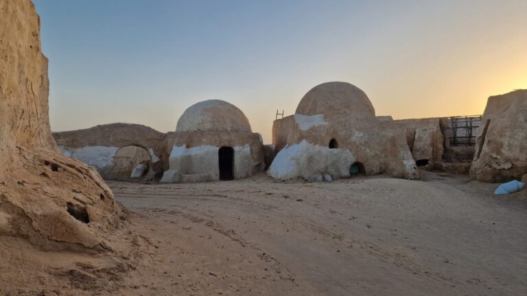 Si vous lisez ces lignes, c'est probablement parce que l'appel du désert commence à se faire sentir. On vous comprend ! Le Sud tunisien n'est pas juste une destination de vacances, c'est une véritable déconnexion, un retour aux sources où le temps semble s'arrêter entre les dunes de sable doré et les oasis verdoyantes. Chez sudtunisie.com, nous avons à cœur de vous faire découvrir cette terre de contrastes d'une manière authentique, loin des sentiers battus et des circuits touristiques standardisés. Que vous soyez un mordu d'adrénaline, un passionné d'histoire ou simplement en quête de sérénité, le Sahara a quelque chose de spécial à vous offrir. Imaginez-vous un instant : le silence absolu du désert, interrompu seulement par le craquement d'un feu de camp, une voûte étoilée d'une pureté incroyable et l'hospitalité légendaire des populations locales. C'est exactement ce que nous vous proposons de vivre. Pour bien préparer votre départ, n'oubliez pas que nous facilitons vos déplacements dès votre arrivée avec nos services de navette aéroport, vous assurant un transfert serein vers le début de votre aventure. Pourquoi choisir un circuit dans le désert avec sudtunisie.com ? On ne s'improvise pas guide de désert. Le Sahara est aussi magnifique qu'exigeant. C'est pourquoi faire appel à des experts locaux est essentiel. Notre approche repose sur la personnalisation. Nous savons que chaque voyageur est unique. Certains préfèrent le confort d'un 4x4 climatisé pour parcourir les pistes du Grand Erg Oriental, tandis que d'autres rêvent de marcher au rythme des caravanes lors d'une méharée traditionnelle. Nous couvrons une zone géographique immense pour vous offrir le meilleur. Nos départs sont organisés depuis les principales villes et zones touristiques du pays. Que vous soyez basé à Tunis, Hammamet, Sousse, ou encore Monastir, Sfax, Djerba, Gabès, Bizerte, Kélibia ou Korba, nous coordonnons votre logistique pour que vous n'ayez qu'à profiter du paysage. En explorant nos différents circuits désert, vous découvrirez des itinéraires pensés pour l'immersion. Nous ne nous contentons pas de vous montrer les dunes ; nous vous emmenons à la rencontre des éleveurs de dromadaires, nous vous faisons goûter au pain de sable cuit sous la braise et nous vous ouvrons les portes des habitations troglodytes de Matmata. Pour nous, le voyage est une question de rencontres et d'émotions. Les incontournables de votre excursion dans le Sud tunisien Le sud de la Tunisie est une mosaïque de paysages. On passe souvent, en quelques kilomètres, d'un plateau aride à une oasis luxuriante. Voici ce qui vous attend lors de vos périples avec nous : Tozeur et Nefta : Les portes du désert Ces deux villes-oasis sont le point de départ idéal pour toute expédition. Tozeur, avec son architecture unique en briques d'argile, possède l'une des plus belles palmeraies du pays. C'est ici que l'on ressent pour la première fois la magie du Sud. Vous pourrez explorer les décors de Star Wars à Ong Jmel, un lieu mythique qui semble sortir tout droit d'une autre planète. Si vous voulez en savoir plus sur les coulisses de ces lieux, jetez un œil à notre blog excursions Tunisie, riche en anecdotes et conseils pratiques. Douz : La porte du Sahara C'est à Douz que l'aventure prend tout son sens. Ici, le bitume s'arrête et le sable commence. C'est le royaume des Mrazig, un peuple de nomades qui a su préserver ses traditions. C'est le lieu parfait pour entamer une randonnée. Si vous aimez combiner les reliefs escarpés et les étendues de sable, notre programme de randonnée montagne et Sahara est fait pour vous. C'est une expérience physique et spirituelle intense, où l'on apprend à respecter la nature dans ce qu'elle a de plus brut. Ksar Ghilane : L'oasis au milieu de nulle part Imaginez une source d'eau chaude naturelle bordée de palmiers, entourée par les dunes rousses du Grand Erg. Ksar Ghilane est un véritable mirage devenu réalité. Se baigner dans ses eaux à 30°C après une journée de piste est un bonheur indescriptible. C'est aussi un point stratégique pour partir plus loin vers le sud, vers des sites plus reculés comme Tembaine. Activités et expériences : Plus qu'une simple visite Une excursion en Tunisie réussie, c'est avant tout une question d'activités qui marquent l'esprit. Nous ne restons pas assis dans la voiture toute la journée ! Nous aimons que nos voyageurs soient acteurs de leur séjour. Nuits en bivouac : Dormir sous une tente berbère ou à la belle étoile est le summum de l'expérience saharienne. Le dîner préparé par nos guides, l'ambiance autour du feu et le lever du soleil sur les dunes sont des moments qui restent gravés à vie. Balades à dos de dromadaire : C'est le moyen de transport ancestral. On avance doucement, on observe les détails du sable, on écoute le vent. C'est une forme de méditation en mouvement. Rencontres chez l'habitant : Dans la région de Tataouine et Chenini, nous vous emmenons visiter les ksours (greniers fortifiés) et partager un thé avec les habitants des villages berbères. C'est là que réside la véritable richesse de la Tunisie : son peuple. Nous savons que l'organisation d'un tel voyage peut soulever des questions sur le budget. C'est pourquoi nous proposons des solutions flexibles. Vous pouvez demander un devis gratuit personnalisé pour ajuster l'itinéraire à vos envies et à votre portefeuille, car nous croyons que le désert doit être accessible à tous ceux qui ont soif d'aventure. L'engagement qualité de sudtunisie.com Pourquoi nous faire confiance plutôt qu'à une agence de masse ? Parce que nous sommes des passionnés du terrain. Notre équipe connaît chaque piste, chaque puits et chaque famille de nomades. Nous privilégions le tourisme responsable. Cela signifie respecter l'environnement fragile du Sahara et s'assurer que les retombées économiques de votre voyage bénéficient directement aux communautés locales. La sécurité est également notre priorité absolue. Nos véhicules sont régulièrement révisés pour affronter les conditions difficiles du désert, et nos chauffeurs-guides sont des experts de la navigation dans les dunes. Ils savent lire le sable comme un livre ouvert. La satisfaction de nos clients est notre meilleure publicité. Nous vous invitons d'ailleurs à consulter les avis de nos voyageurs sur TripAdvisor pour voir ce qu'ils ont pensé de leur immersion avec nous. Leurs témoignages parlent souvent de "choc émotionnel", de "beauté sauvage" et de "liens humains forts". Préparez votre sac pour le Grand Sud ! Partir en excursion dans le désert demande un minimum de préparation. Voici quelques petits conseils d'amis pour ne rien oublier : Vêtements : Prévoyez des couches. Il peut faire très chaud la journée et surprenamment frais la nuit. Des vêtements longs en coton sont parfaits pour se protéger du soleil et du sable. Protection : Crème solaire, lunettes de soleil de qualité et un chèche (le foulard traditionnel) sont indispensables. Le chèche n'est pas qu'un accessoire de mode, c'est la meilleure protection contre le vent et la chaleur. Appareil photo : Chargez vos batteries ! Vous allez vouloir capturer chaque instant, même si aucune photo ne rendra jamais totalement justice à l'immensité du Sahara. Esprit ouvert : C'est l'élément le plus important. Soyez prêt à sortir de votre zone de confort, à déconnecter de votre téléphone et à vous laisser porter par le rythme du désert. Si vous hésitez encore sur le choix de votre itinéraire, n'attendez plus. Le désert change, bouge, et chaque saison offre une lumière différente. Que vous partiez de Tunis ou de Djerba, l'aventure commence dès que vous franchissez le premier oued. Pour transformer ce rêve en réalité, vous pouvez nous contacter directement pour un devis voyage désert sud Tunisie. Nous nous ferons un plaisir de construire avec vous le voyage de votre vie, celui qui vous fera dire, en rentrant, que vous avez laissé une petite partie de votre âme dans les sables de Tunisie. Alors, on se voit bientôt sous les palmiers ? Le Sud vous attend, et nous sommes prêts à vous y conduire avec toute la passion et le professionnalisme qui nous caractérisent. À très bientôt pour une aventure hors du commun !